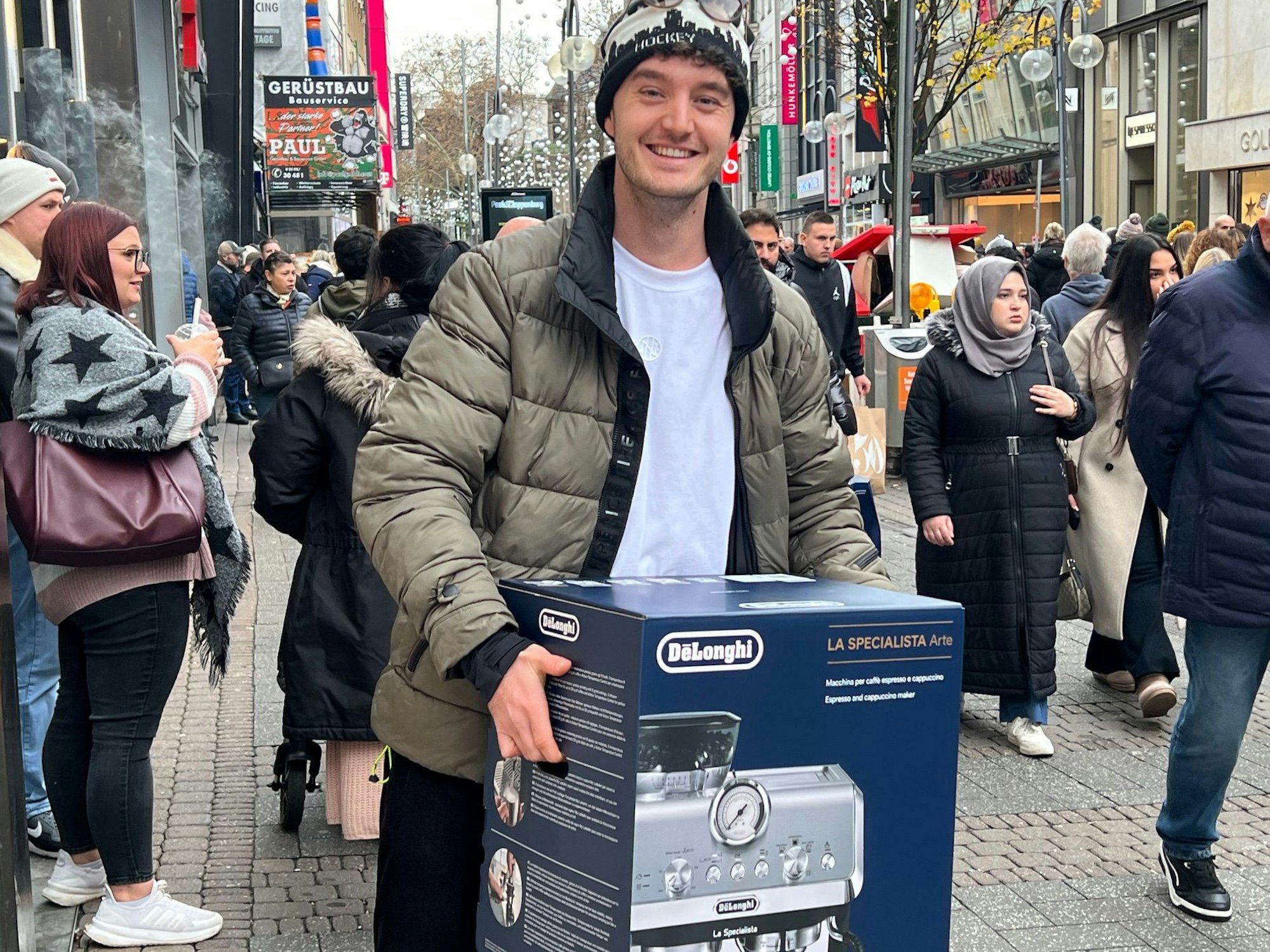 Jan N. hat sich eine Siebträgermaschine mit Black-Friday-Angebot gekauft. Er hat die Menschenmenegen unterschätzt und braucht kurz eine Pause, bevor er weiter zur Bahn läuft.