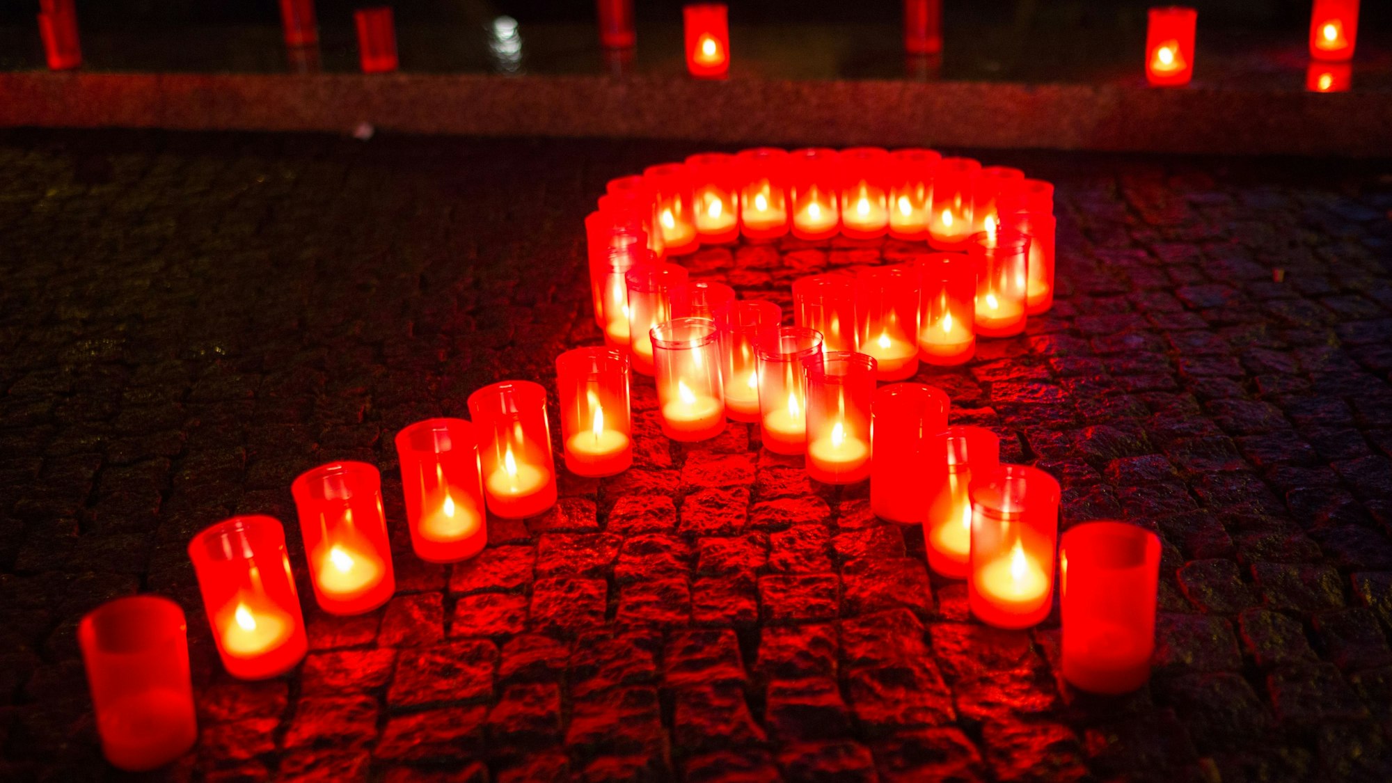 Kerzen bilden eine rote Schleife. Dies ist ein Symbol für den Kampf gegen Aids. Der Welt-Aids-Tag ist am 1. Dezember. (Archivbild)