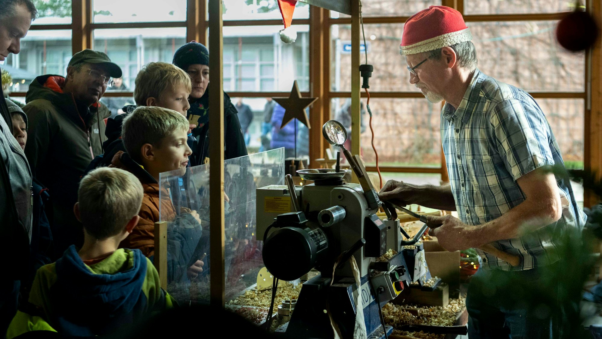 Das Bild zeigt einen Handwerker, der an der Drechsel steht.