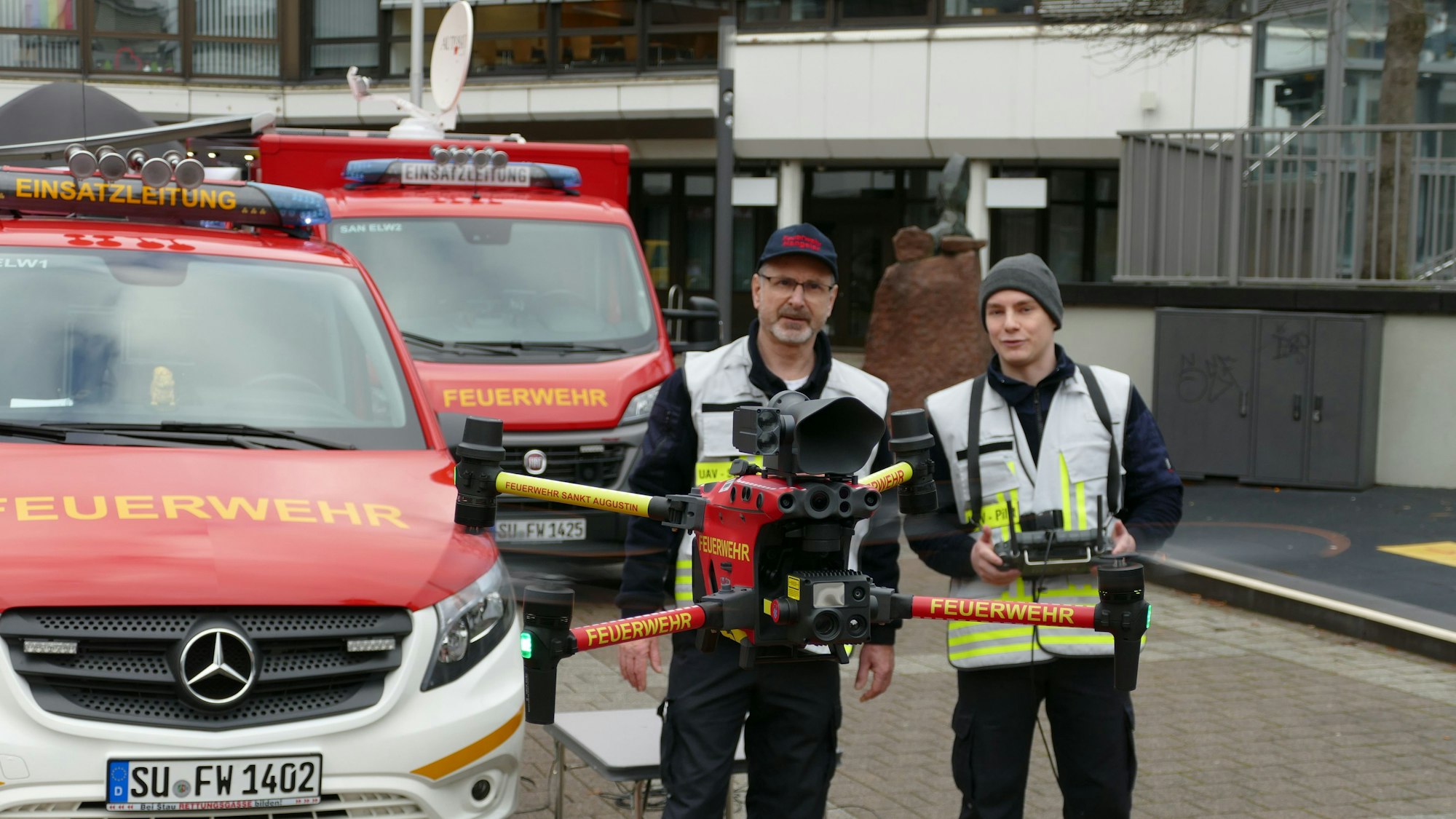 Zwei Mitglieder der Feuerwehr führen eine Drohne vor.