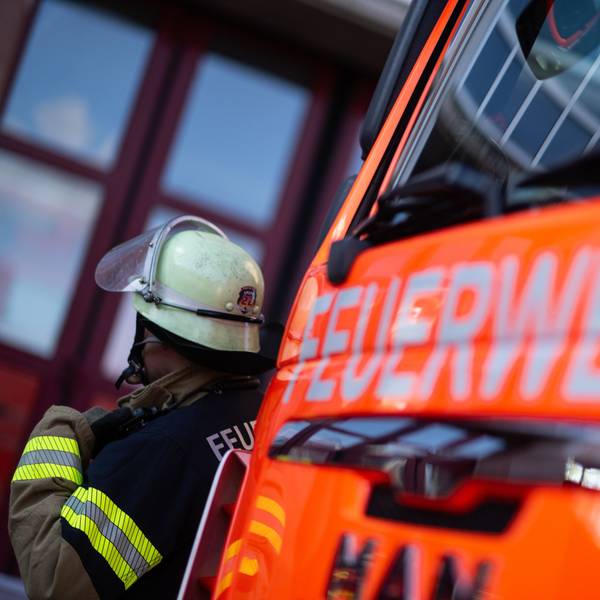 Eine Einsatzkraft der Feuerwehr steht neben einem Einsatzfahrzeug der Feuerwehr (gestellte Szene). (zu dpa: «Ein Toter bei Wohnungsbrand in Ketsch») +++ dpa-Bildfunk +++