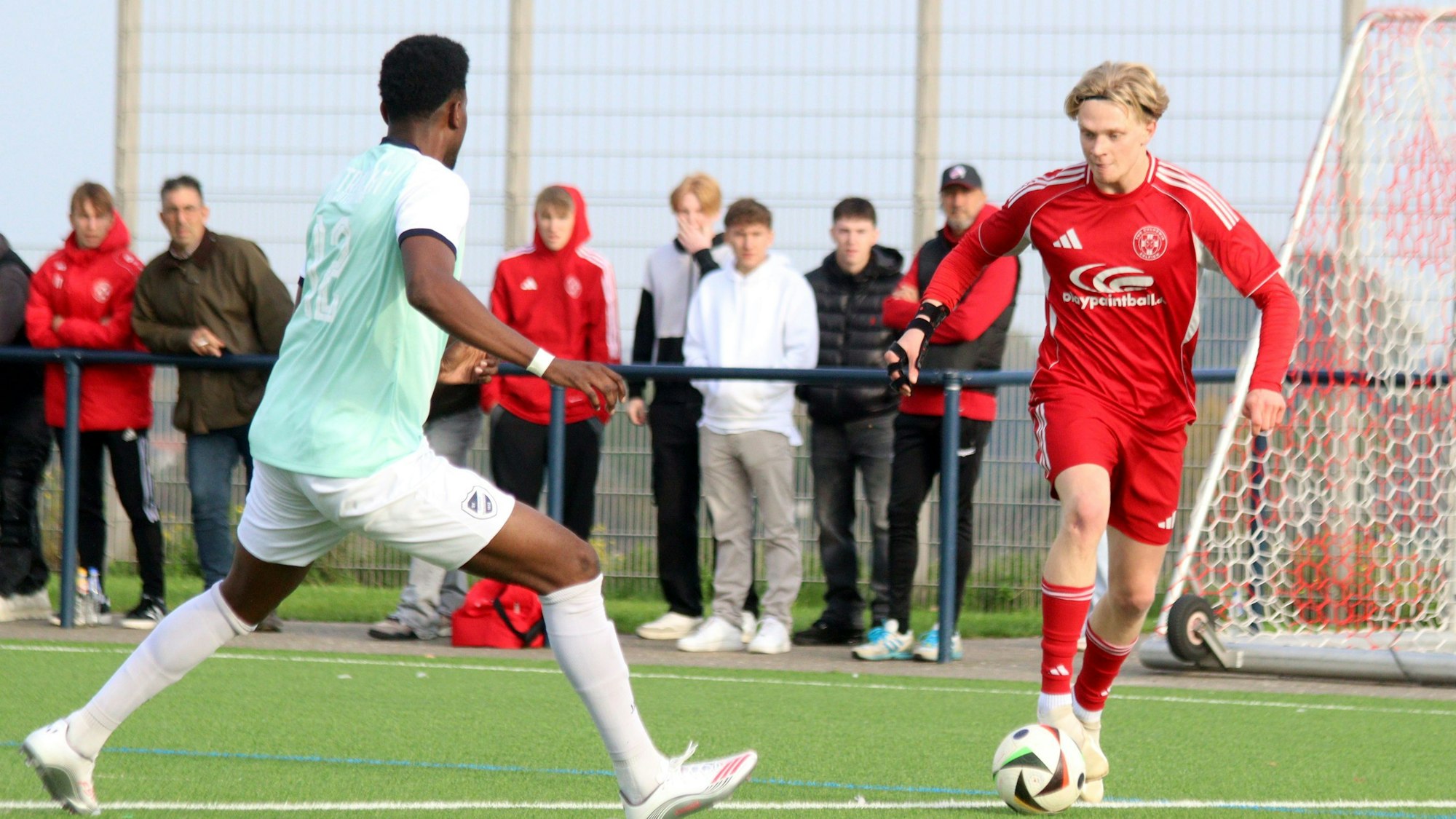 Birkenheuer dribbelt mit dem Ball auf einen Gegenspieler zu, im Hintergrund Zuschauer.