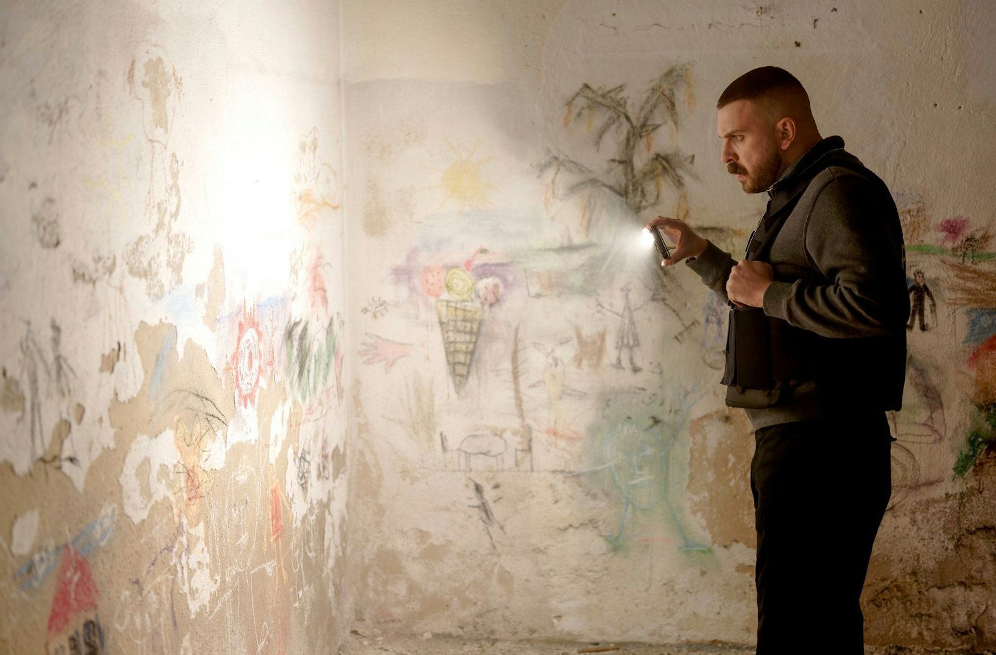 Was haben Kinderhände und -herzen hier geschaffen? Hamza Kulina (Edin Hasanovic) erkundet eine Wand. (Bild: HR/Sommerhaus/Tatiana Vdovenko)