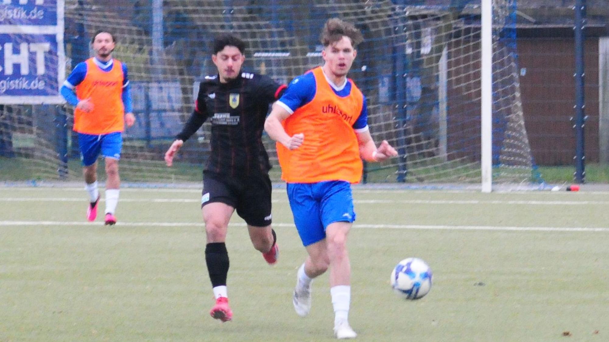 Das Foto zeigt einen Königsdorfer Spieler, im orangefarbenen Leibchen, der seinen Dürener Gegenspieler hinter sich lässt.
