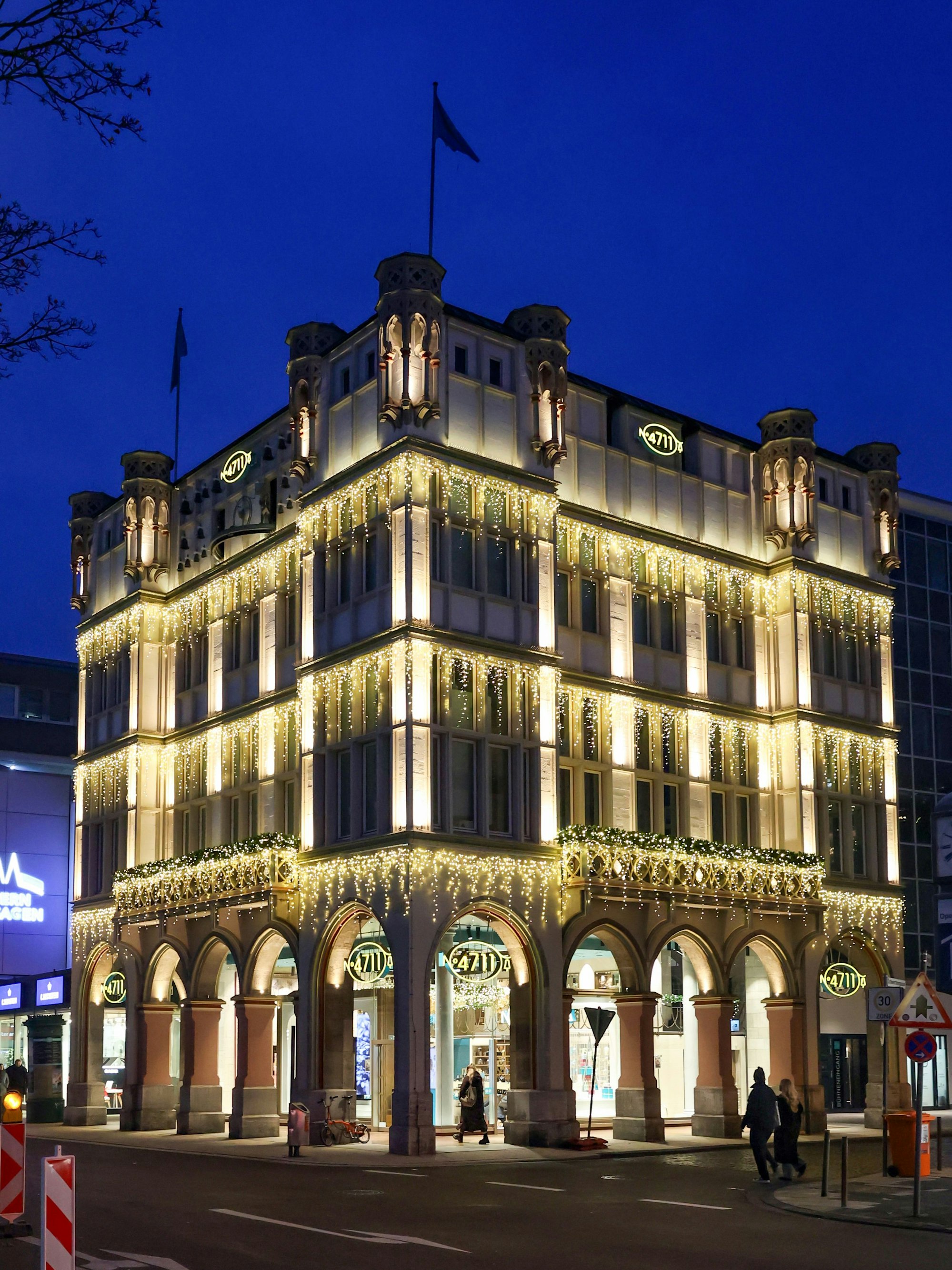 Festlich beleuchtetes Gebäude mit Bogengang von der Marke 4711.