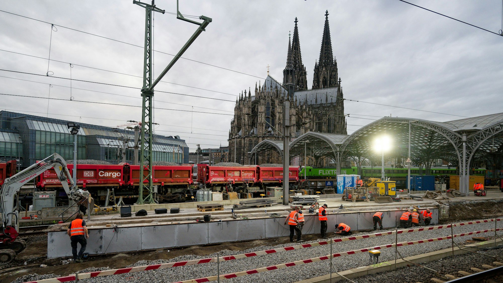 ARCHIV - 14.11.2025, Nordrhein-Westfalen, Köln: Arbeiter in Warnwestern sind am Hauptbahnhof Köln vor dem Kölner Dom beschäftigt. Nach zehn Tagen Sperrung am Kölner Hauptbahnhof sollen alle Züge ab Montagmorgen wieder nach regulärem Plan fahren. Pendler und Fernreisende kommen ab 5.00 Uhr wieder ohne Umstieg bis ins Zentrum der Millionenstadt. (zu dpa: «Nach Sperrung bald wieder normaler Bahn-Betrieb in Köln») Foto: Henning Kaiser/dpa +++ dpa-Bildfunk +++