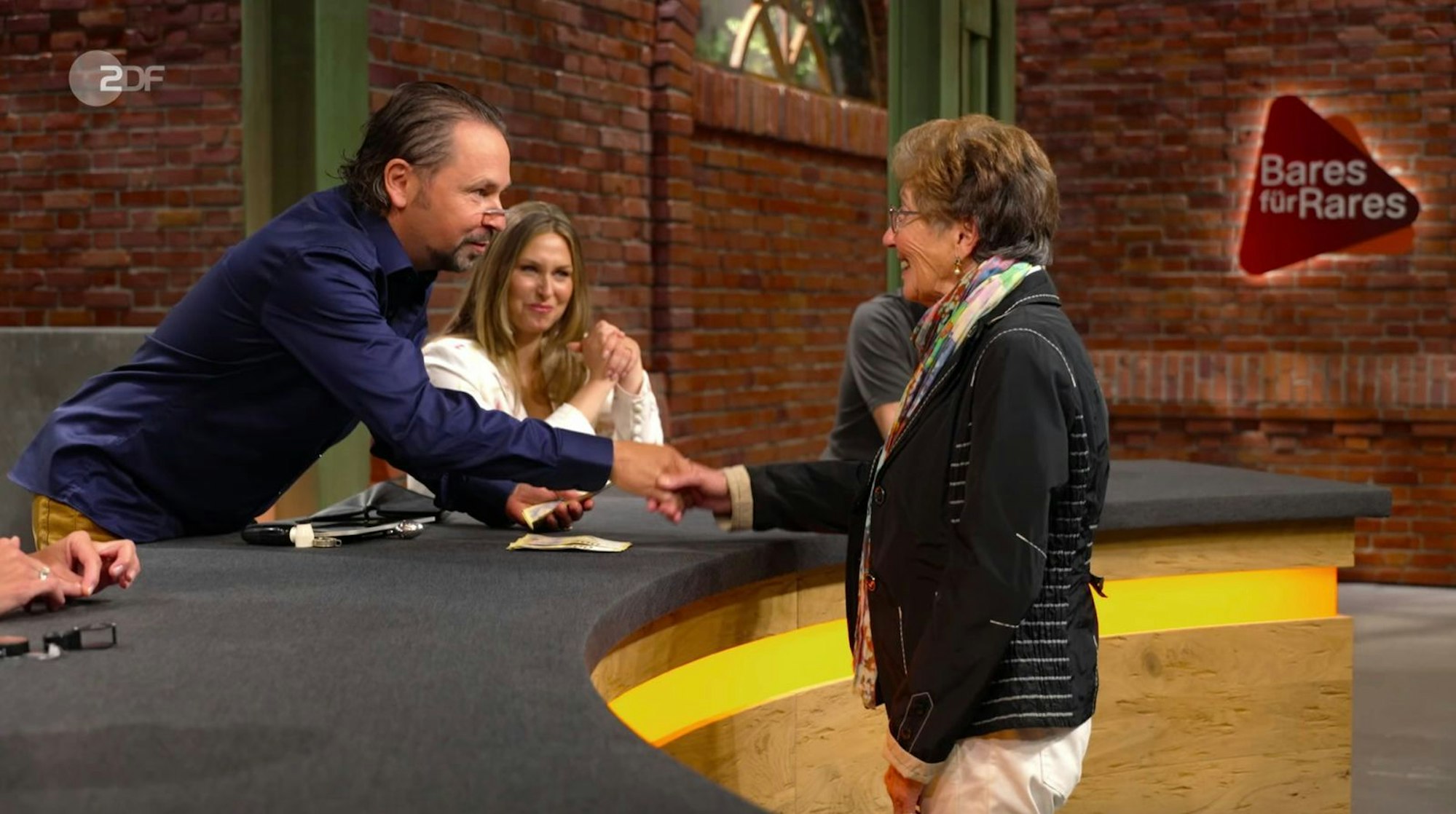 Pauritsch erhielt schließlich bei 3.000 Euro den Zuschlag. Danach überschütten ihn alle mit Glückwünschen für das „grafische Kunstwerk im tollen Zustand, von einer tollen Firma“. (Bild: ZDF)