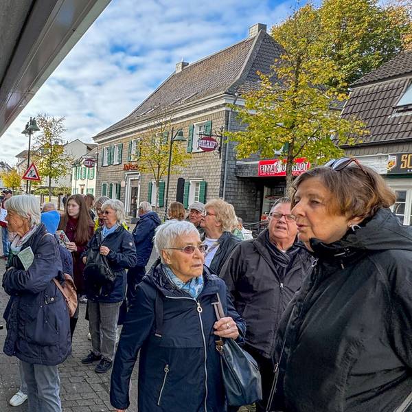 Anwohnerinnen und Anwohner schauen sich die Werke bei „Kunst in Schlebuscher Schaufenstern“ an.