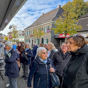 Anwohnerinnen und Anwohner schauen sich die Werke bei „Kunst in Schlebuscher Schaufenstern“ an.