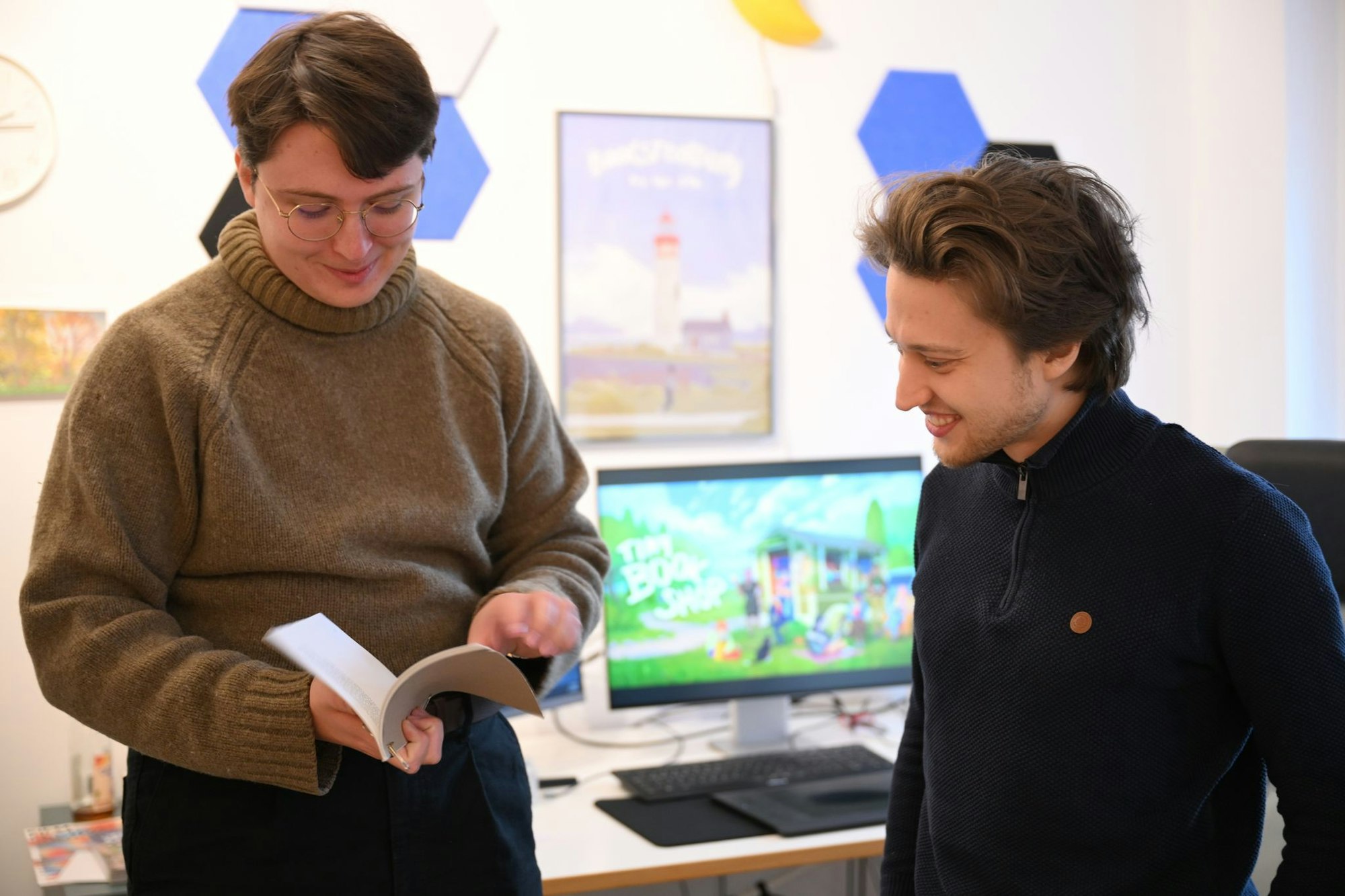 Zapfe-Wildemann hält ein Heft in der Hand, in dem Regeln für eine analoge Version von «Tiny Bookshop» stehen.