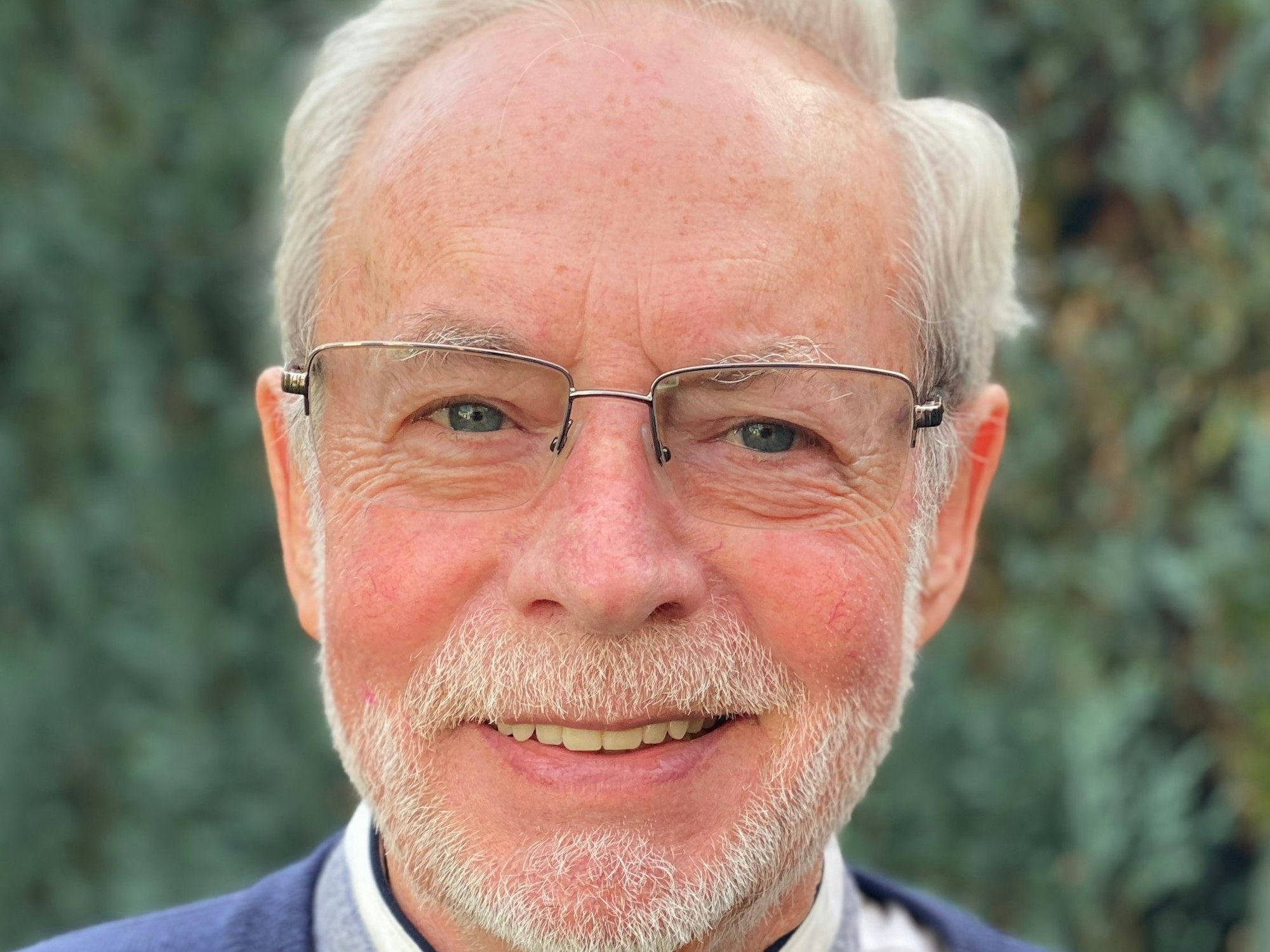 Das Bild zeigt ein Porträt von Rudi Esch, der in die Kamera lächelt.