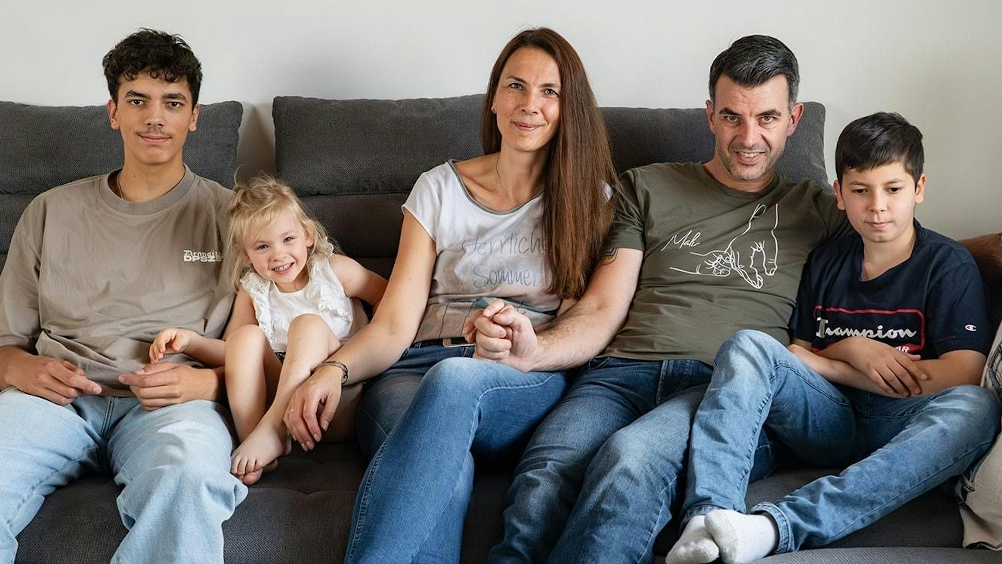 Das Bild zeigt die Familie auf dem Sofa