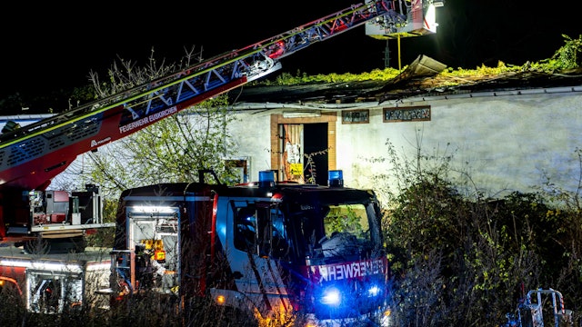 Ein Feuerwehrauto steht vor einem Gebäude, die Drehleiter ist ausgefahren.