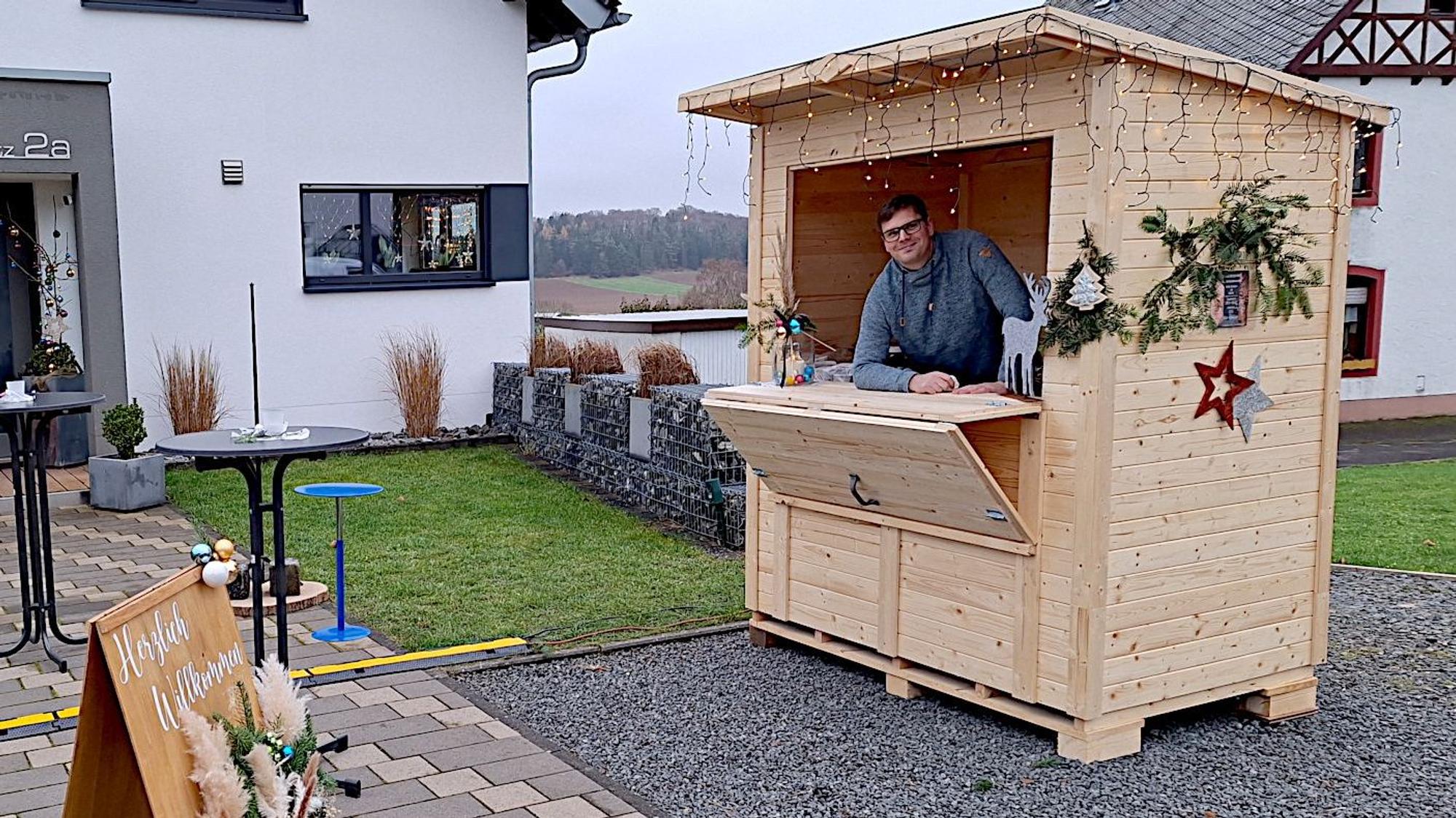 Dominique Zinner steht in einem Holzbüdchen, das eine Verkaufsklappe hat.