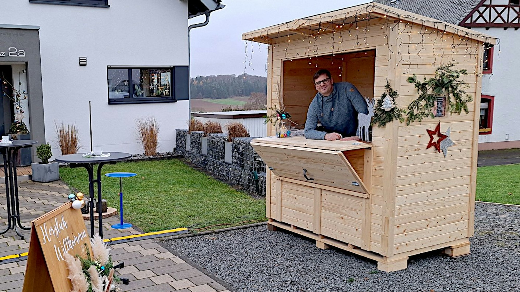Dominique Zinner steht in einem Holzbüdchen, das eine Verkaufsklappe hat.