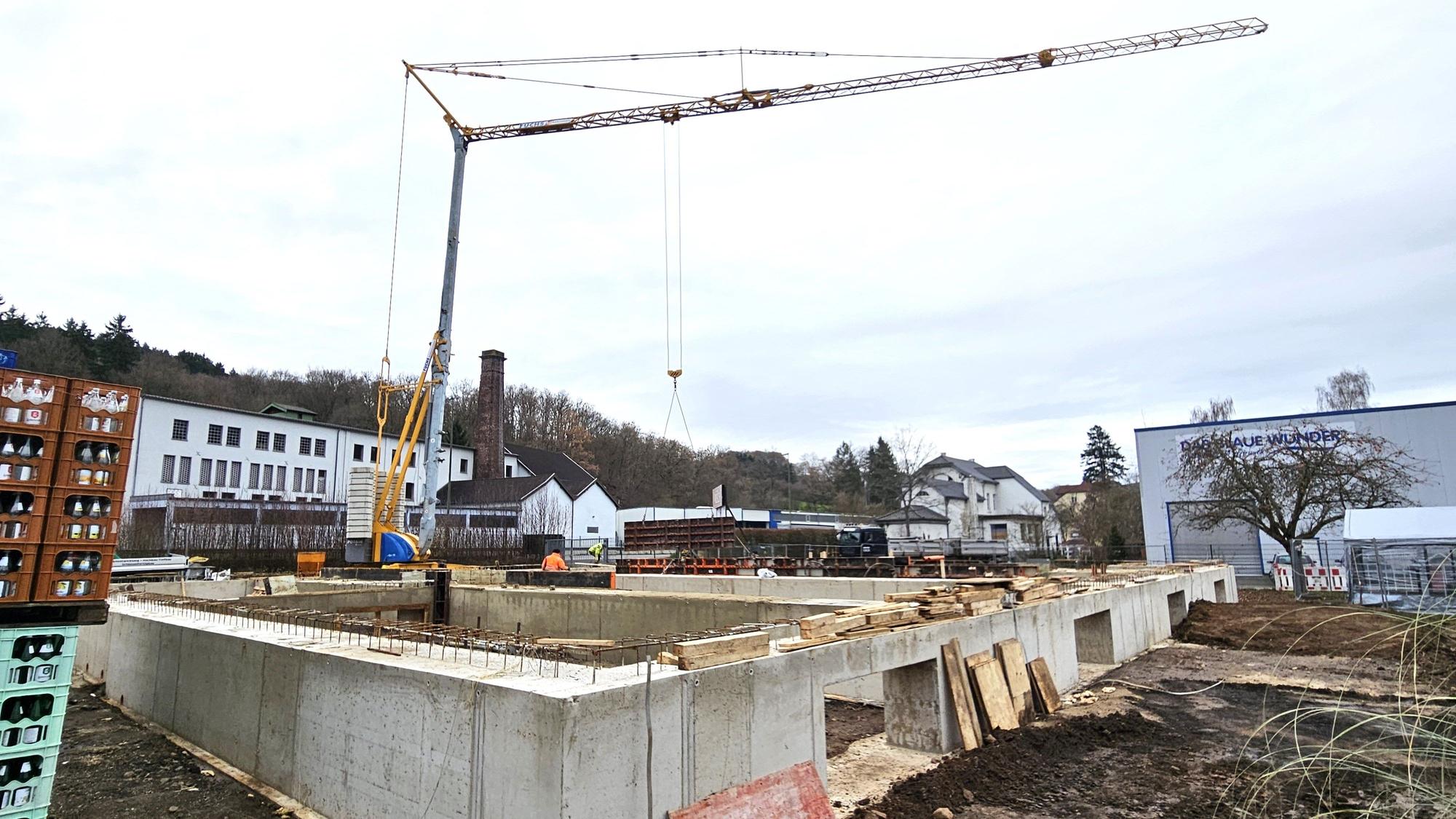 Blick auf das Betonstreifenfundament und den Baukran.