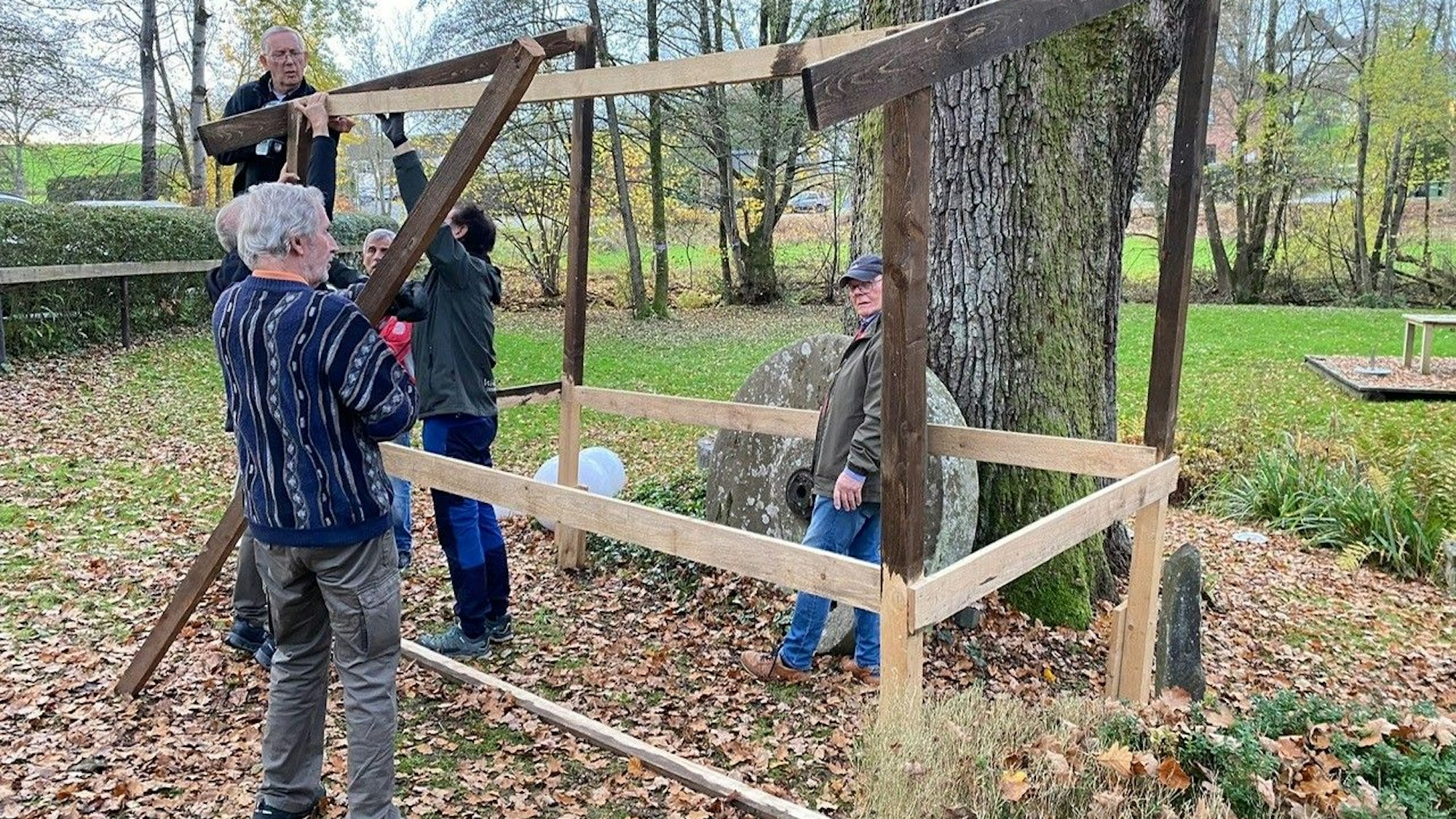 Die Ehrenamtler bauen eine Krippe in der Landschaft auf.