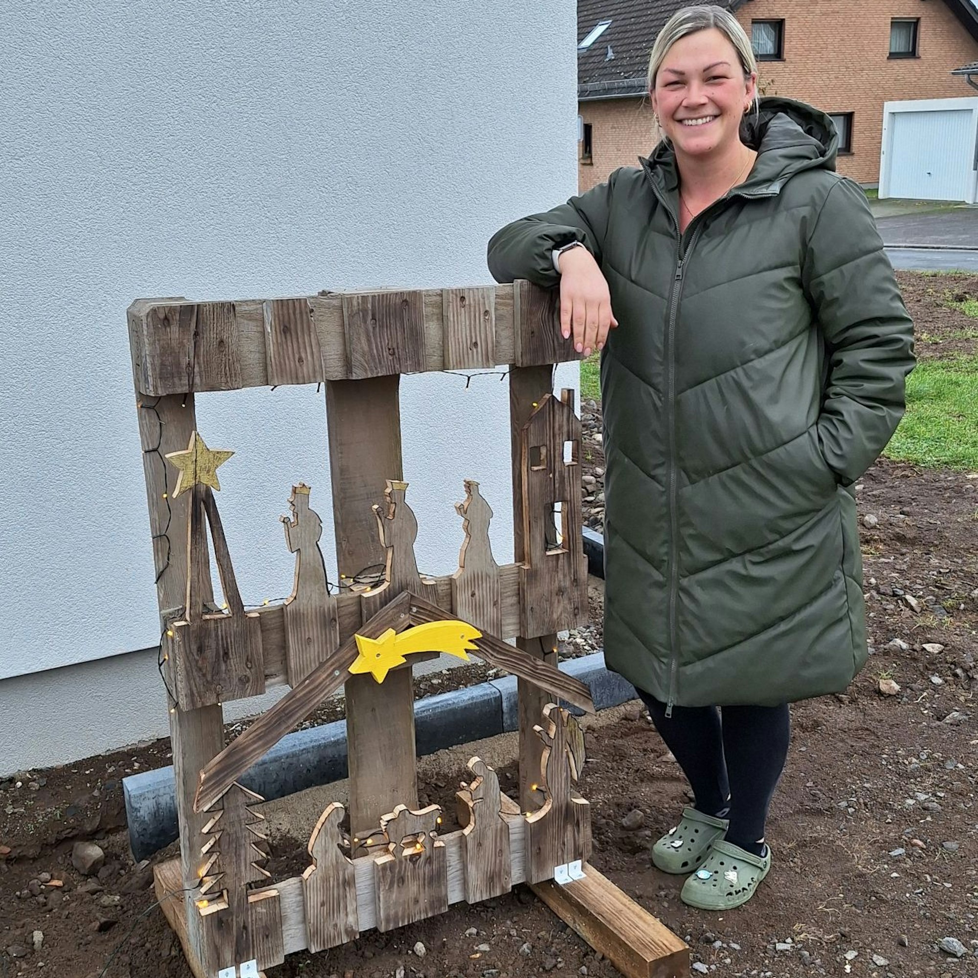 Leona Esser lehnt an ihrer selbst gebauten Krippe, die zum Krippenweg in Blankenheim-Ripsdorf gehört.