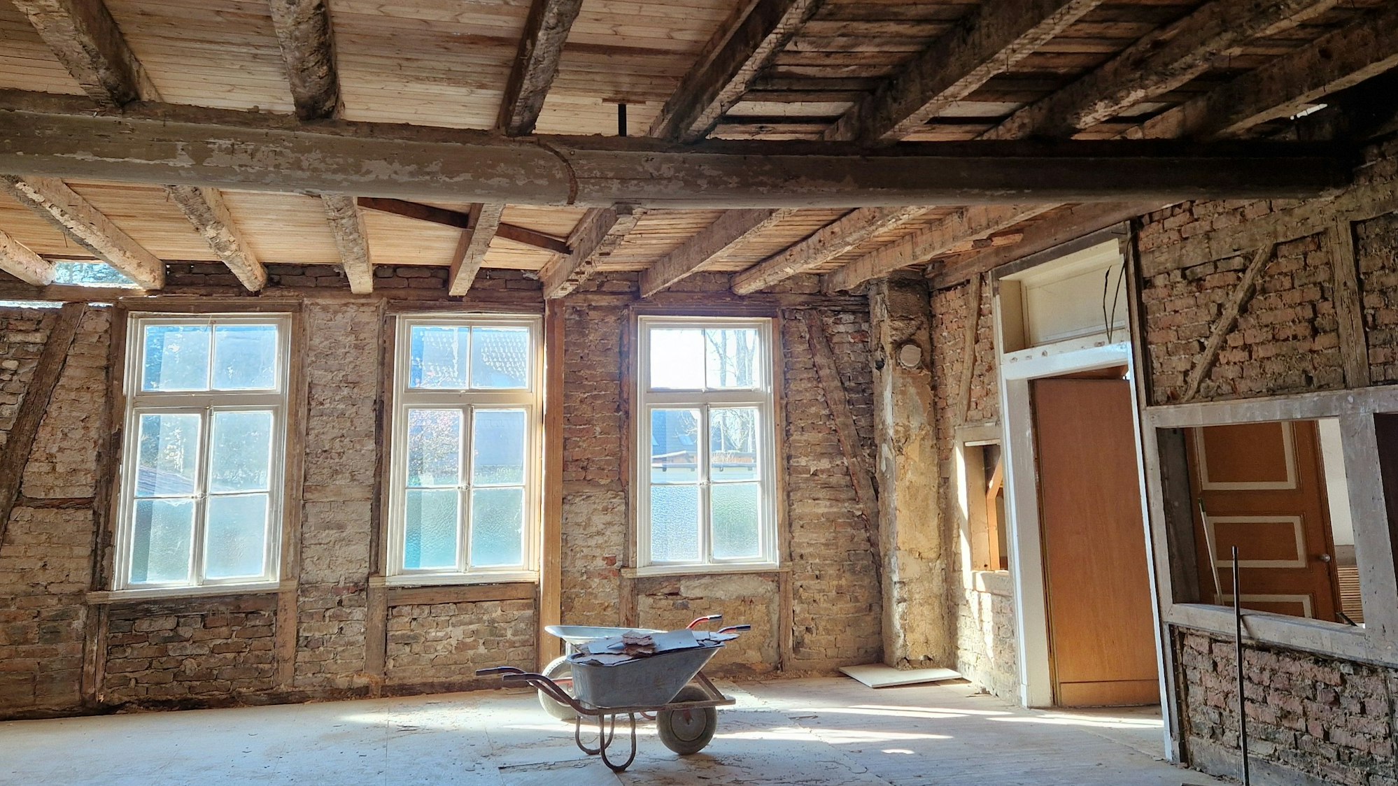 Zu sehen ist ein alter Saal, in dem das Fachwerk freigelegt ist.