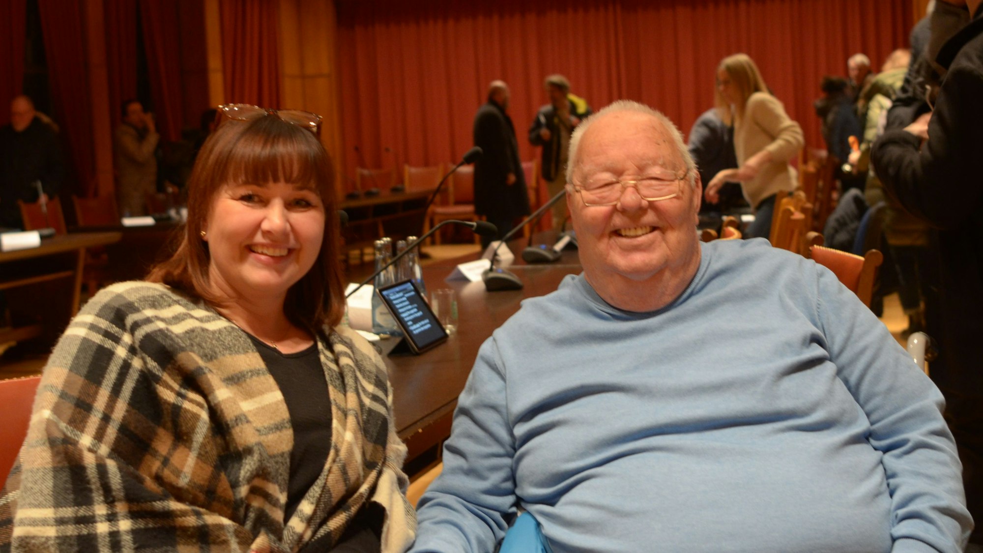 Günther-Merzenich und Hachenberg sitzen nebeneinander im Euskirchener Ratssaal und lachen in die Kamera.