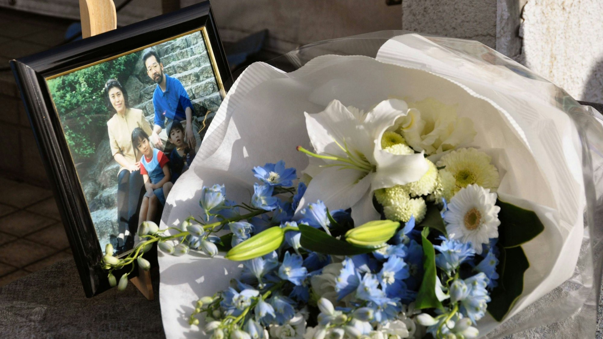 Blumen und ein Foto der Familie Miyazawa erinnern an Mikio und Yasuko sowie die Kinder Niina und Rei.