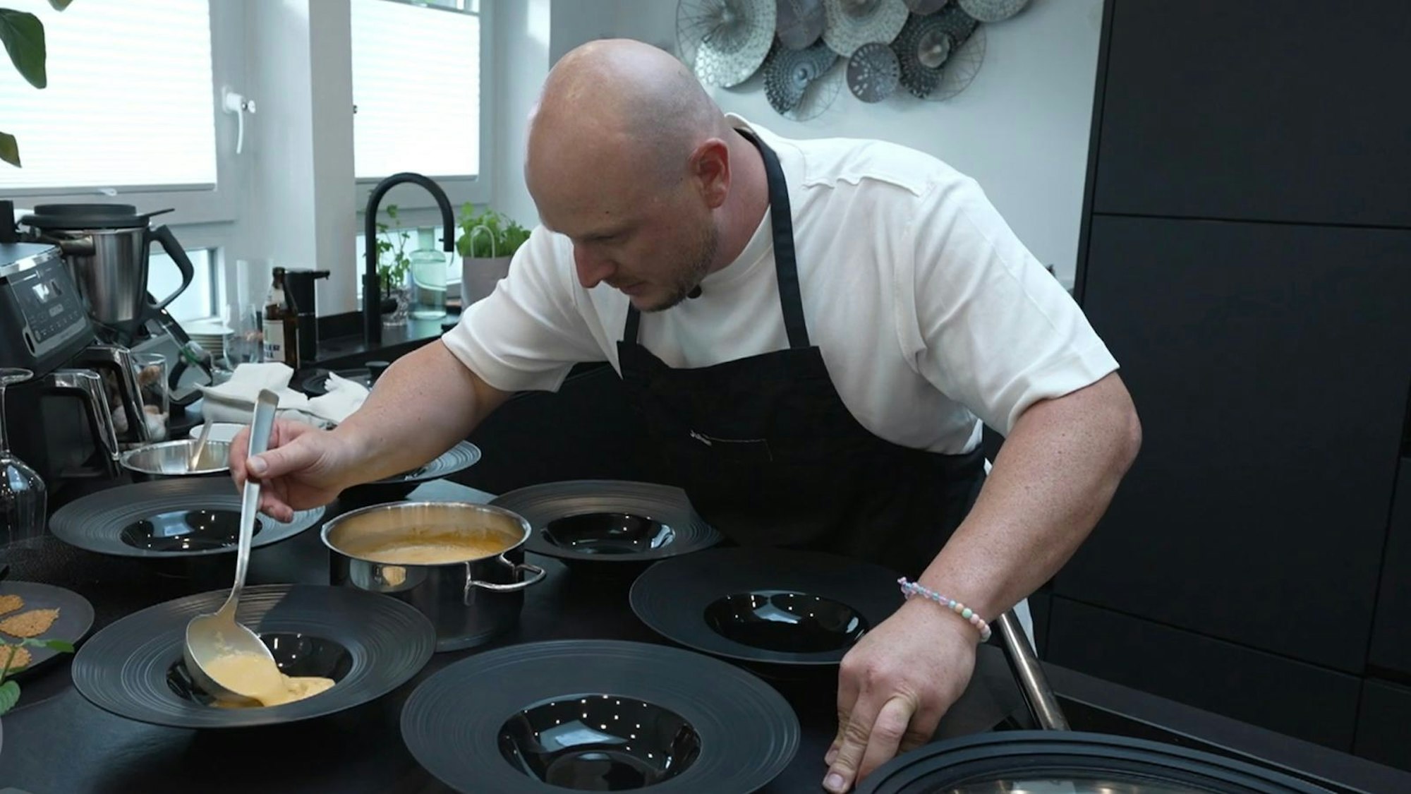 Julian (36) ist beim Anrichten der Hummersuppe höggscht konzentriert. (Bild: RTL)