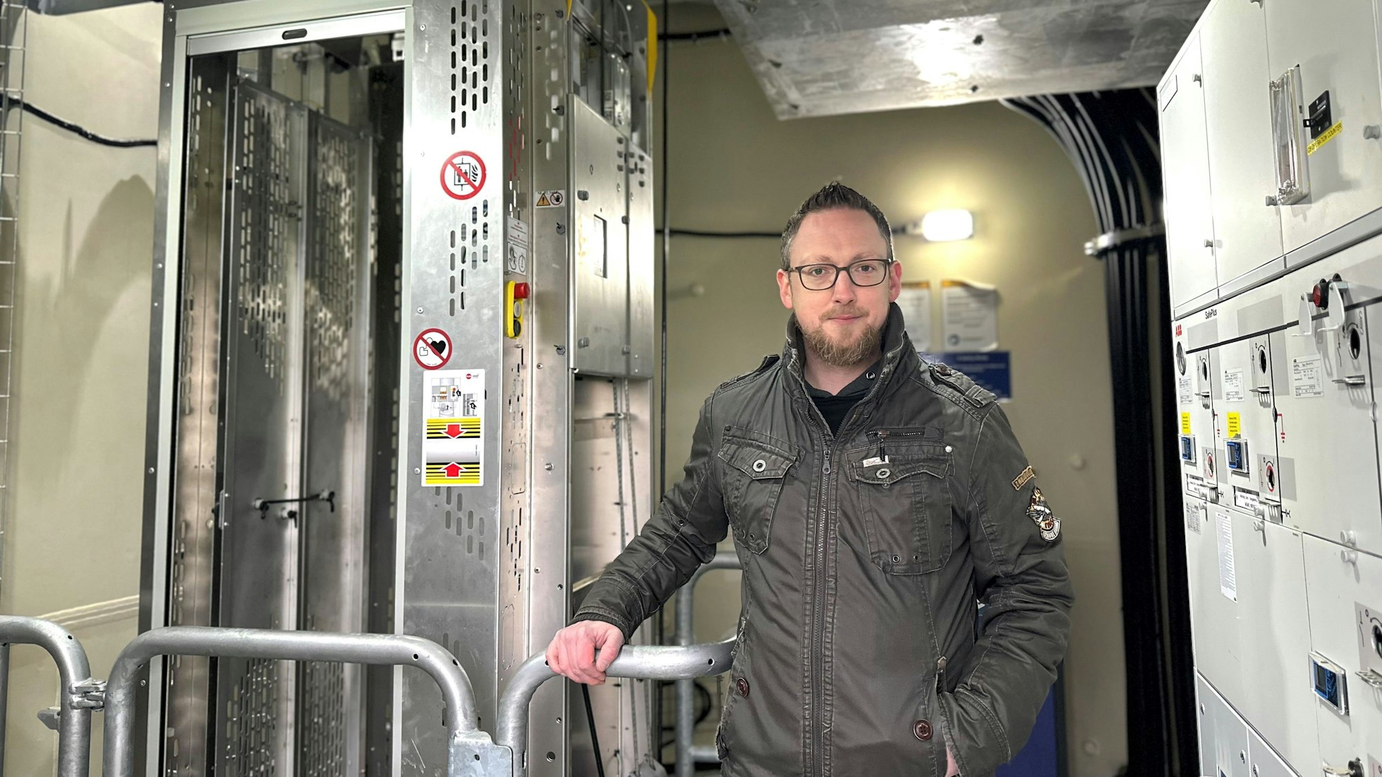 Ein Mann steht in einem Windrad neben einem Aufzug.