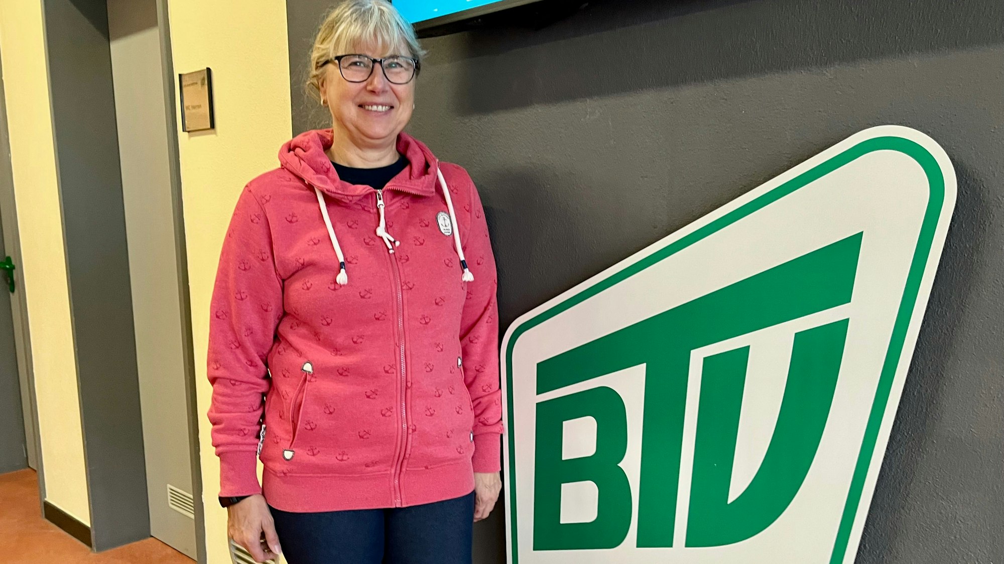 Zu sehen ist Martina Scholl vor dem Vereinslogo des BTV.