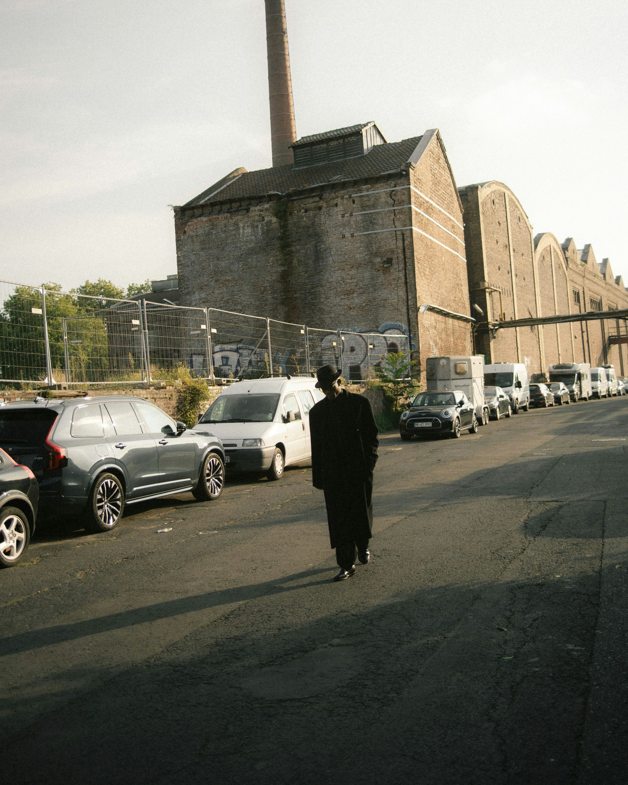 Das Bild zeigt den Künstler Don L. Gaspár vor Industriekulisse. Ali Foto: Binh Minh Dao