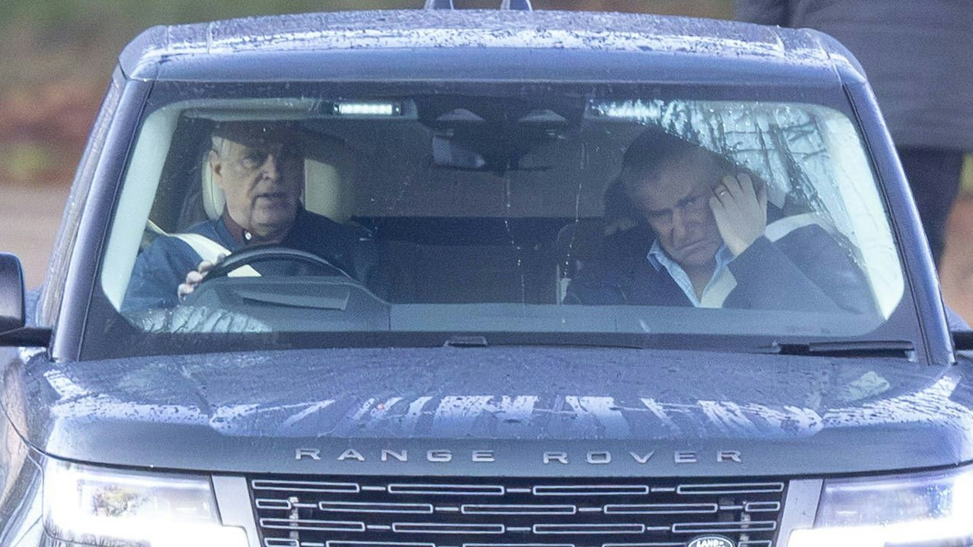 Andrew Mountbatten-Windsor fährt einen dunklen Range Rover mit einem nachdenklichen Passagier im Regen.