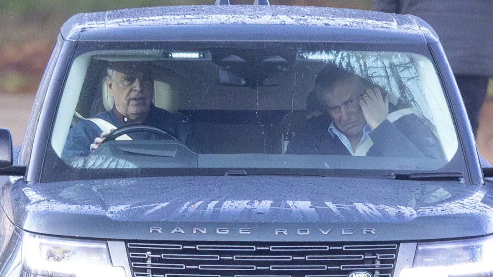 Andrew Mountbatten-Windsor fährt einen dunklen Range Rover mit einem nachdenklichen Passagier im Regen.