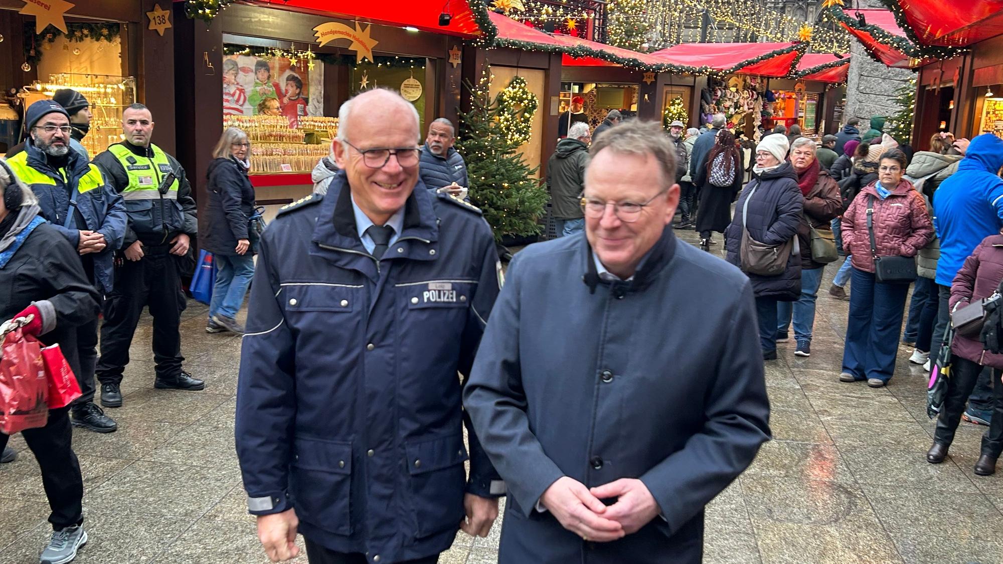 Kölns Oberbürgermeister Torsten Burmester (SPD) und Polizeidirektor Martin Lotz (links) beim Rundgang über den Weihnachtsmarkt am Dom.