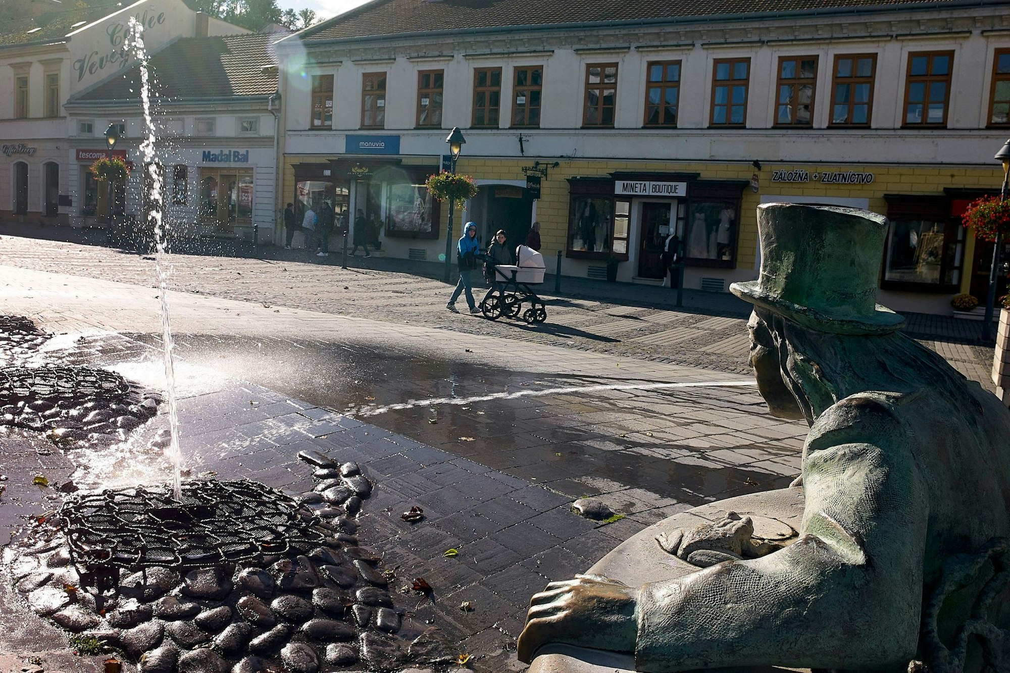 Ein Wassermann sprüht eine Fontäne auf einem Platz in der Fußgängerzone im Zentrum der slowakischen Stadt Trencin.