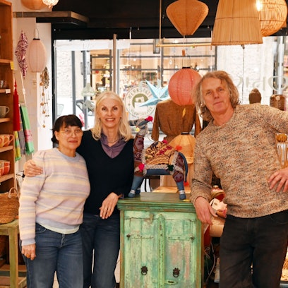 02.12.2025 Köln. Oh-Calcutta-Geschäft in der Innenstadt schließt nach 29 Jahren zum Jahresende (indische Möbel und Besonderheiten aus aller Welt). Patricia Schlüter und Norbert Wiefers mit Mitarbeiterin Yasmin Gönenc (links). Foto: Alexander Schwaiger