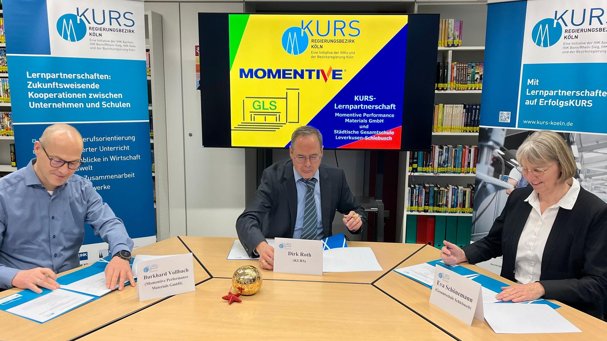 Burkhard Vollbach von Momentive, Kurs-Koordinator Dirk Roth und Schulleiterin Eva Schönemann unterschreiben die Kooperationsvereinbarung.