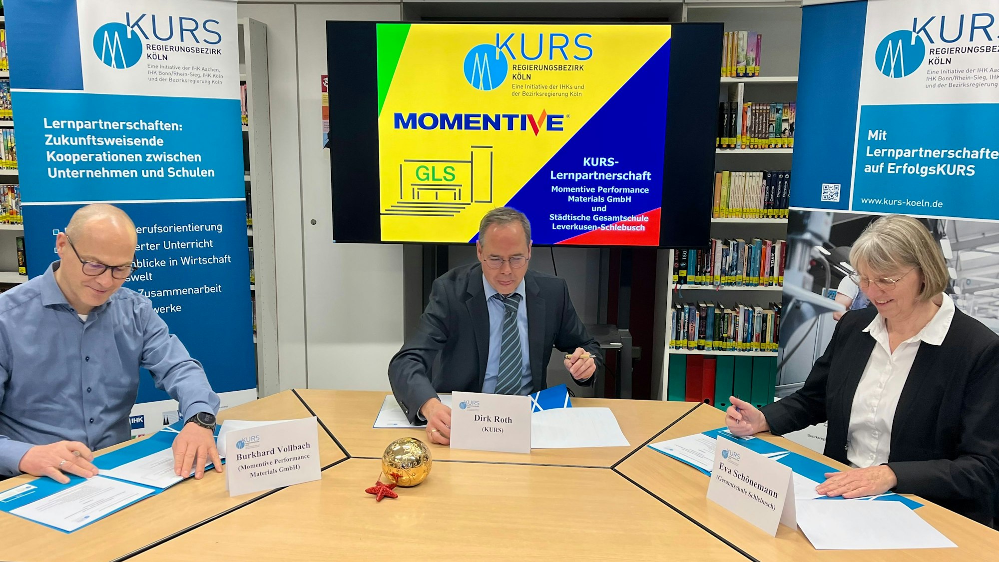 Burkhard Vollbach von Momentive, Kurs-Koordinator Dirk Roth und Schulleiterin Eva Schönemann unterschreiben die Kooperationsvereinbarung.