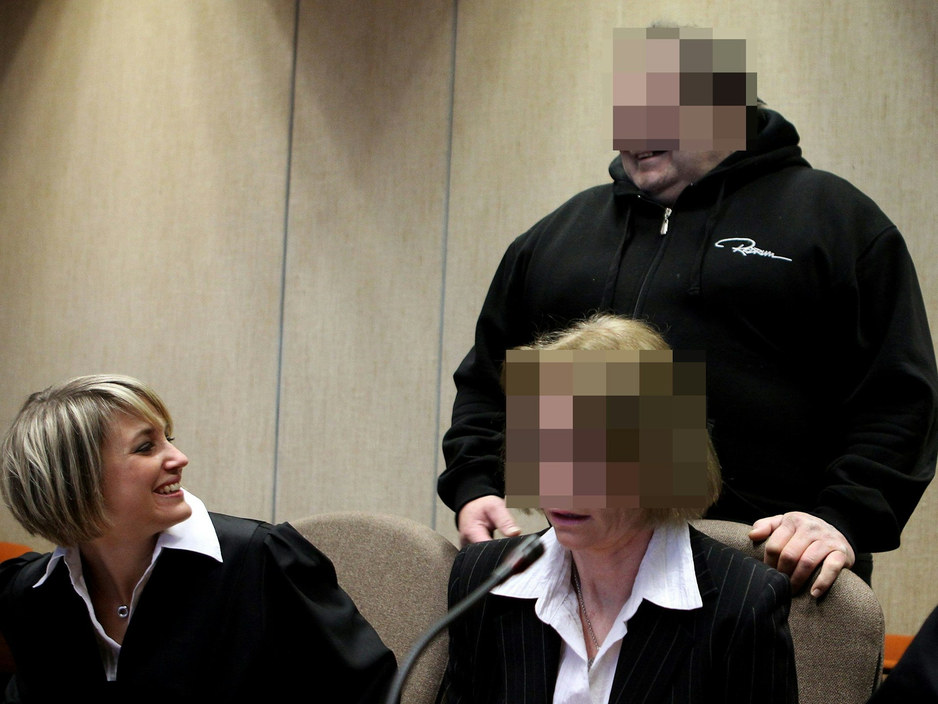 Erich L. lächelt Verteidigerin Julia von Dreden beim Prozessbeginn an, neben der Anwältin sitzt die Mitangeklagte.