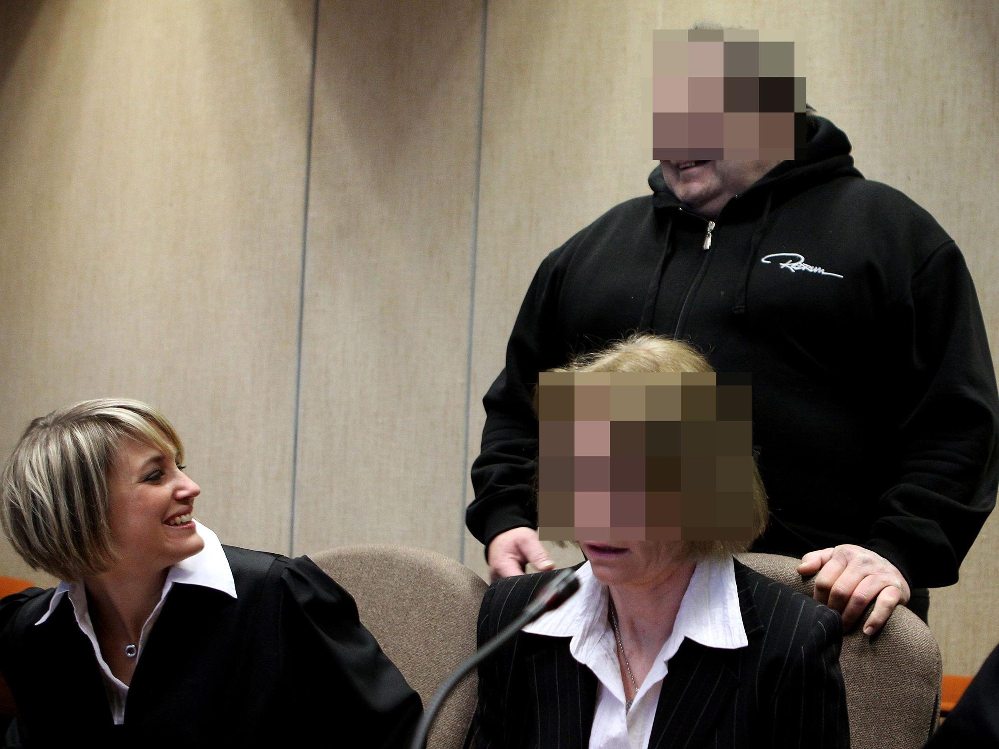 Erich L. lächelt Verteidigerin Julia von Dreden beim Prozessbeginn an, neben der Anwältin sitzt die Mitangeklagte.