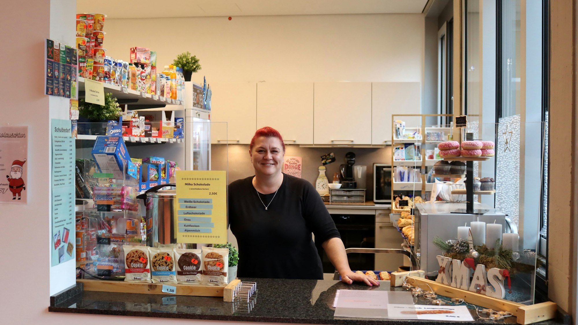 Yvonne Oster stützt sich auf die Theke des Kiosks, auf der unter anderem ein Adventskranz steht.