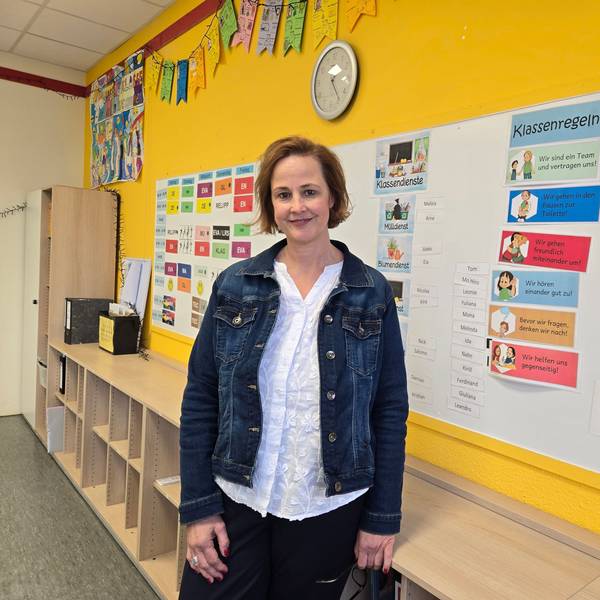 Eine Frau vor einer Pinnwand in der Schule.