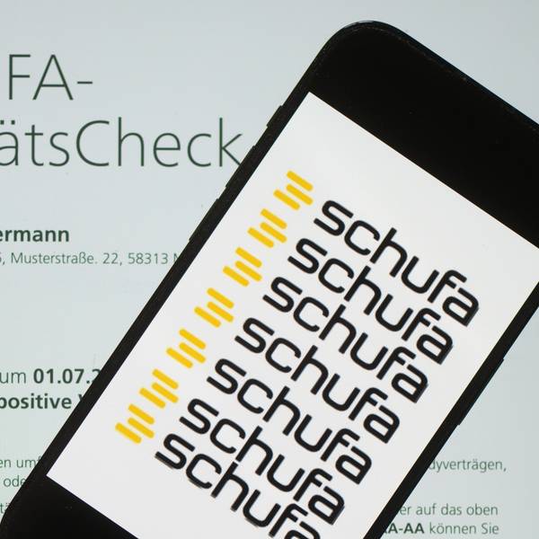 Das Logo der Wirtschaftsauskunftei Schufa liegt auf einem Display mit einem Musterdokument eines Schufa-Bonitätszertifikats. (Symbolbild)