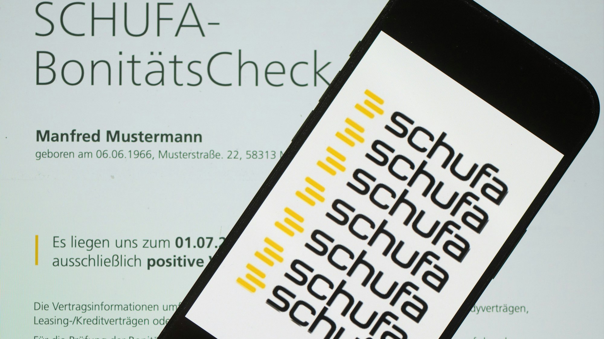 Das Logo der Wirtschaftsauskunftei Schufa liegt auf einem Display mit einem Musterdokument eines Schufa-Bonitätszertifikats. (Symbolbild)