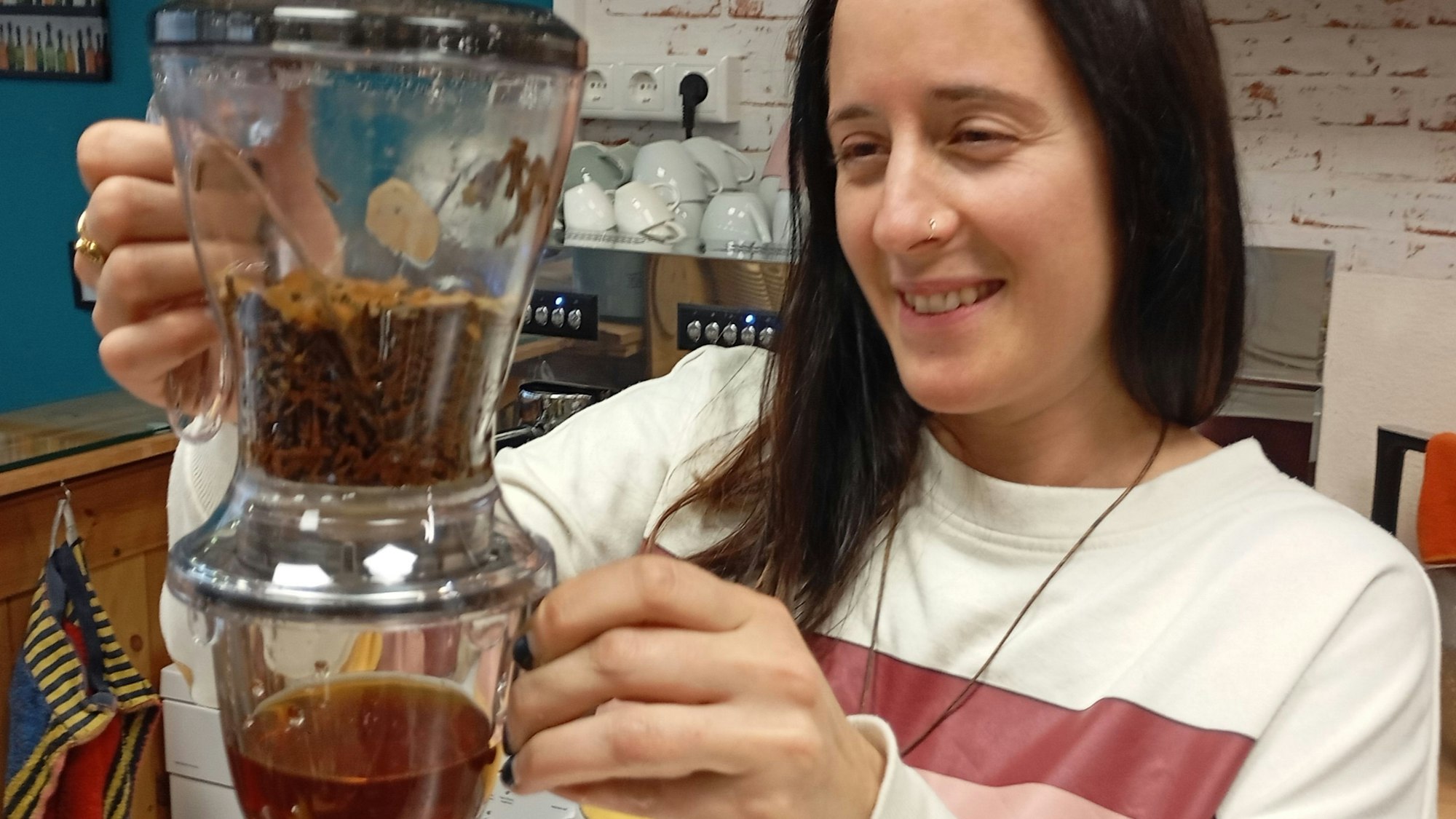 Das Foto zeigt eine Frau, die Tee zubereitet.