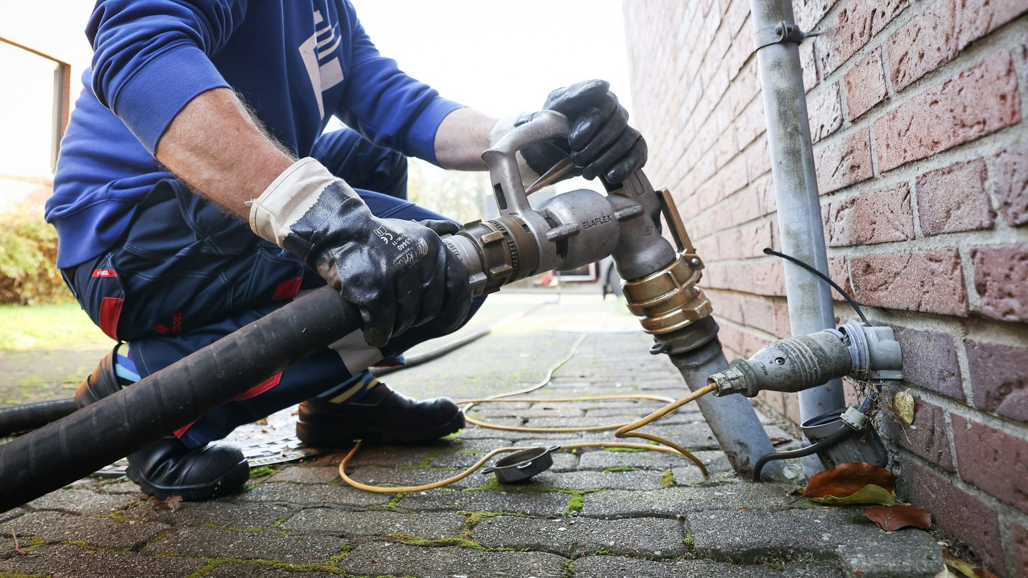 Ein Mitarbeiter eines Heizöl-Unternehmens befestigt die Zapfpistole an einem Füllstutzen für die Heizöllieferung an einen Kunden in einem Einfamilienhaus. (Archivbild)