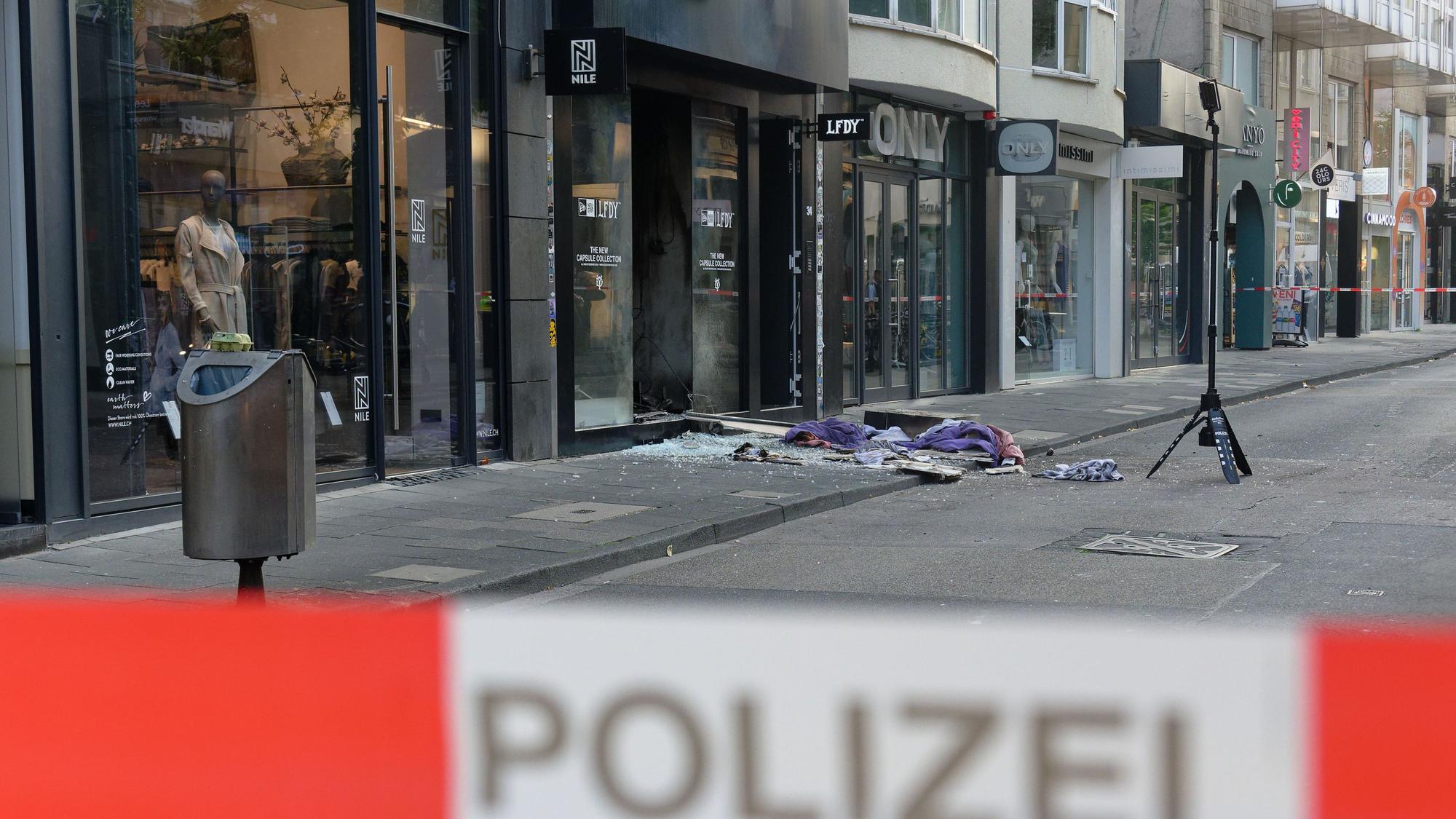 Scherben und Kleidungsstücke liegen nach der Explosion vor dem Geschäft in der Ehrenstraße in Köln.