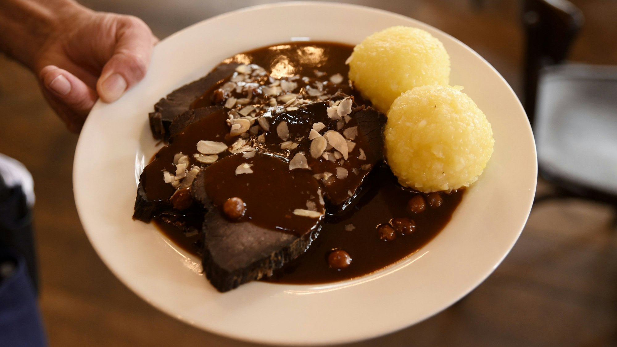 Im Restaurant Max Stark gibt es noch das traditionelle kölsche Ur-Gericht Sauerbraten vom Pferd, hier auf dem Teller mit Soße und Klößen. (Archivbild)