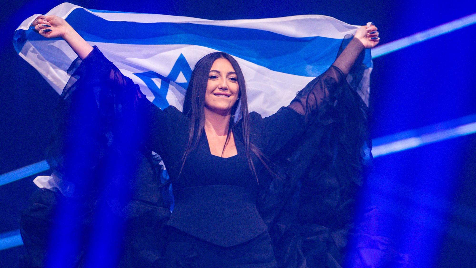 16.05.2025, Schweiz, Basel: Yuval Raphael aus Israel kommt mit der Landesfahne bei einer Probe für die Finalshow des 69. Eurovision Song Contest in der Arena St. Jakobshalle auf die Bühne.