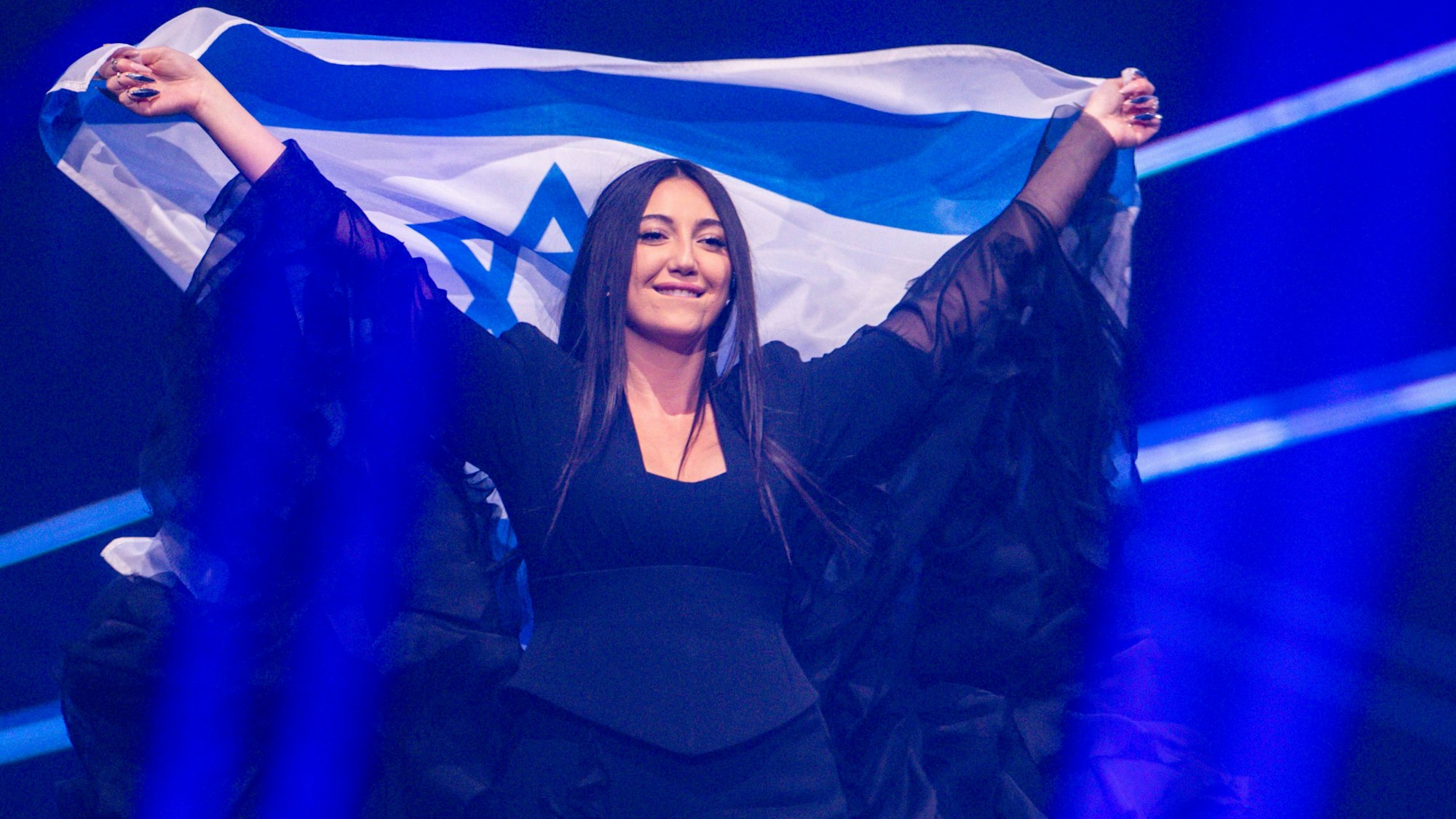 16.05.2025, Schweiz, Basel: Yuval Raphael aus Israel kommt mit der Landesfahne bei einer Probe für die Finalshow des 69. Eurovision Song Contest in der Arena St. Jakobshalle auf die Bühne.