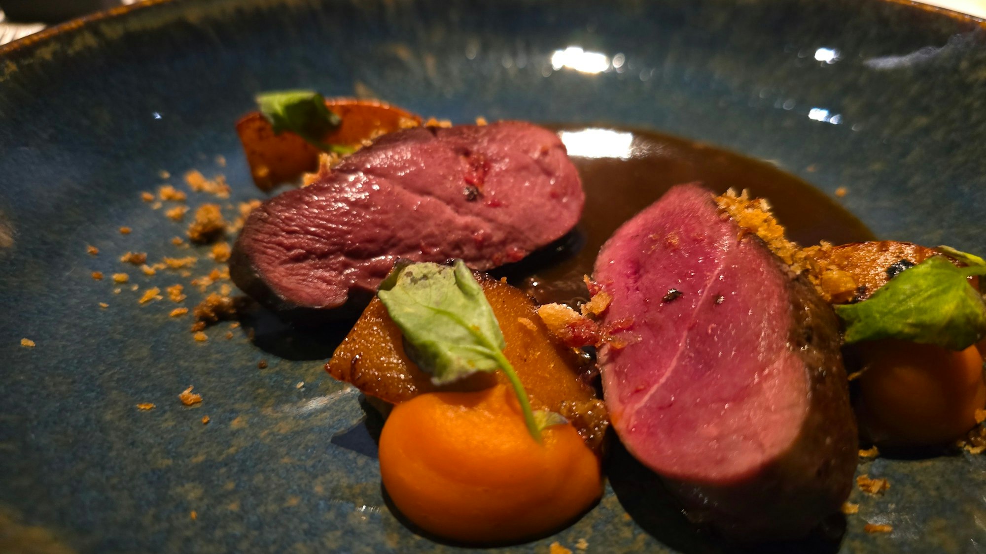 Tellergericht mit aufgeschnittenem, rosa gebratenem Entenfleisch.