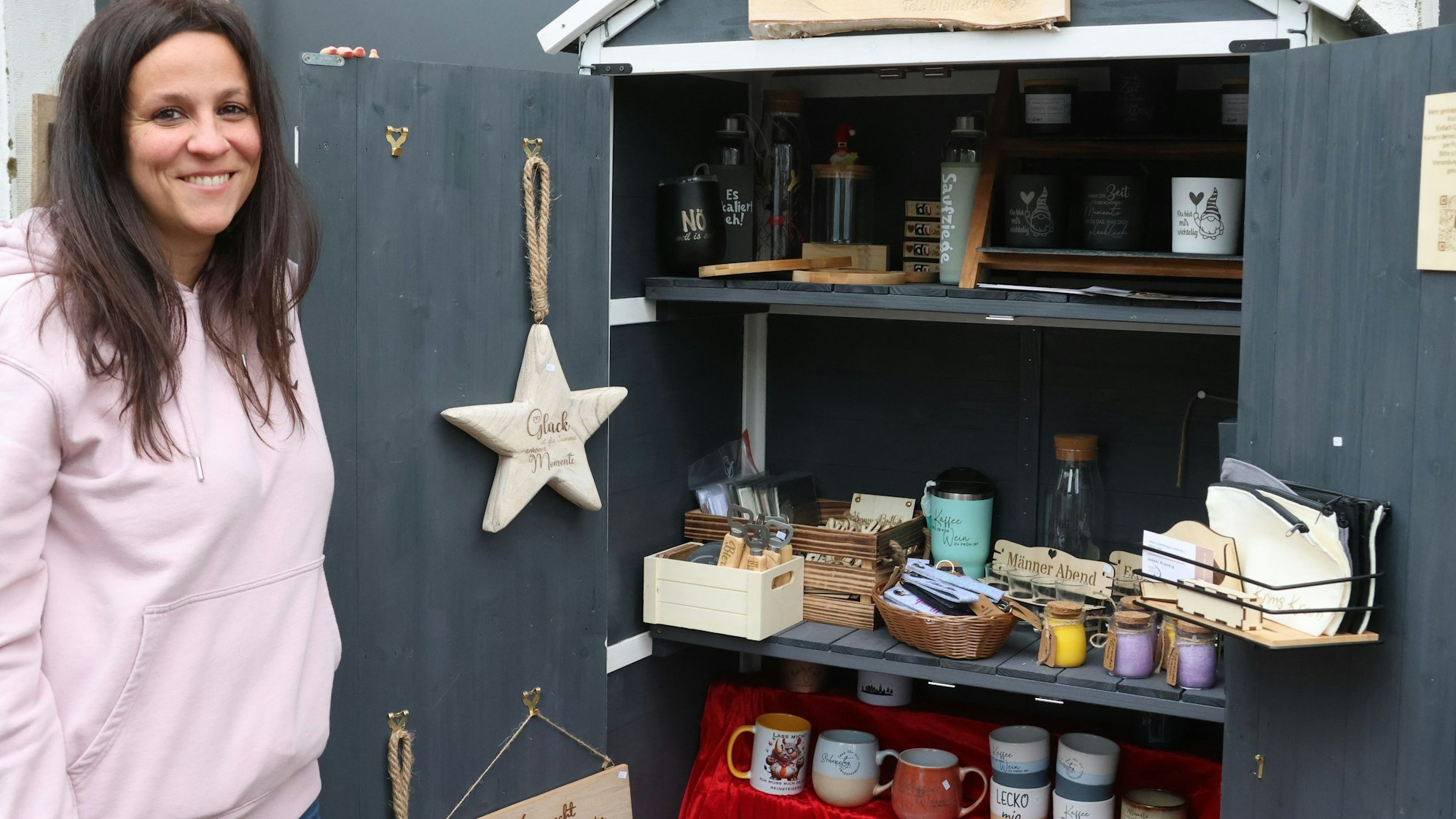 Einblick ins Sortiment: Die Künstlerin Angela Bottiglieri bietet ihre auch Ware in einem Verkaufsschrank vor ihrem Haus in der Reichshofer Ortschaft Erdingen an. Das Foto zeigt die 41-Jährige neben dem Stand vor der eigenen Haustür.